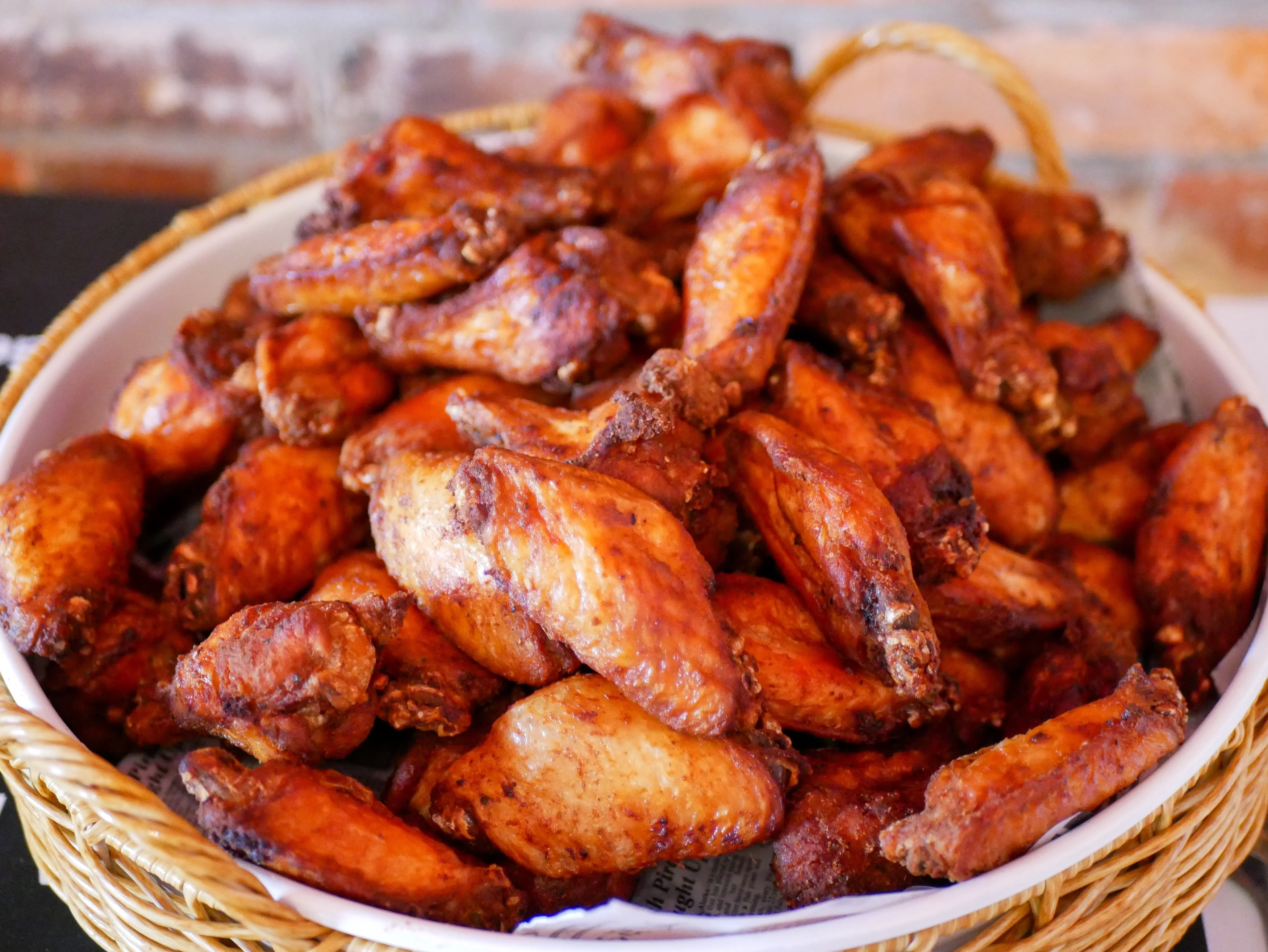 A large serving of crispy chicken wings presented in a bowl, showcasing their golden-brown color and texture.
