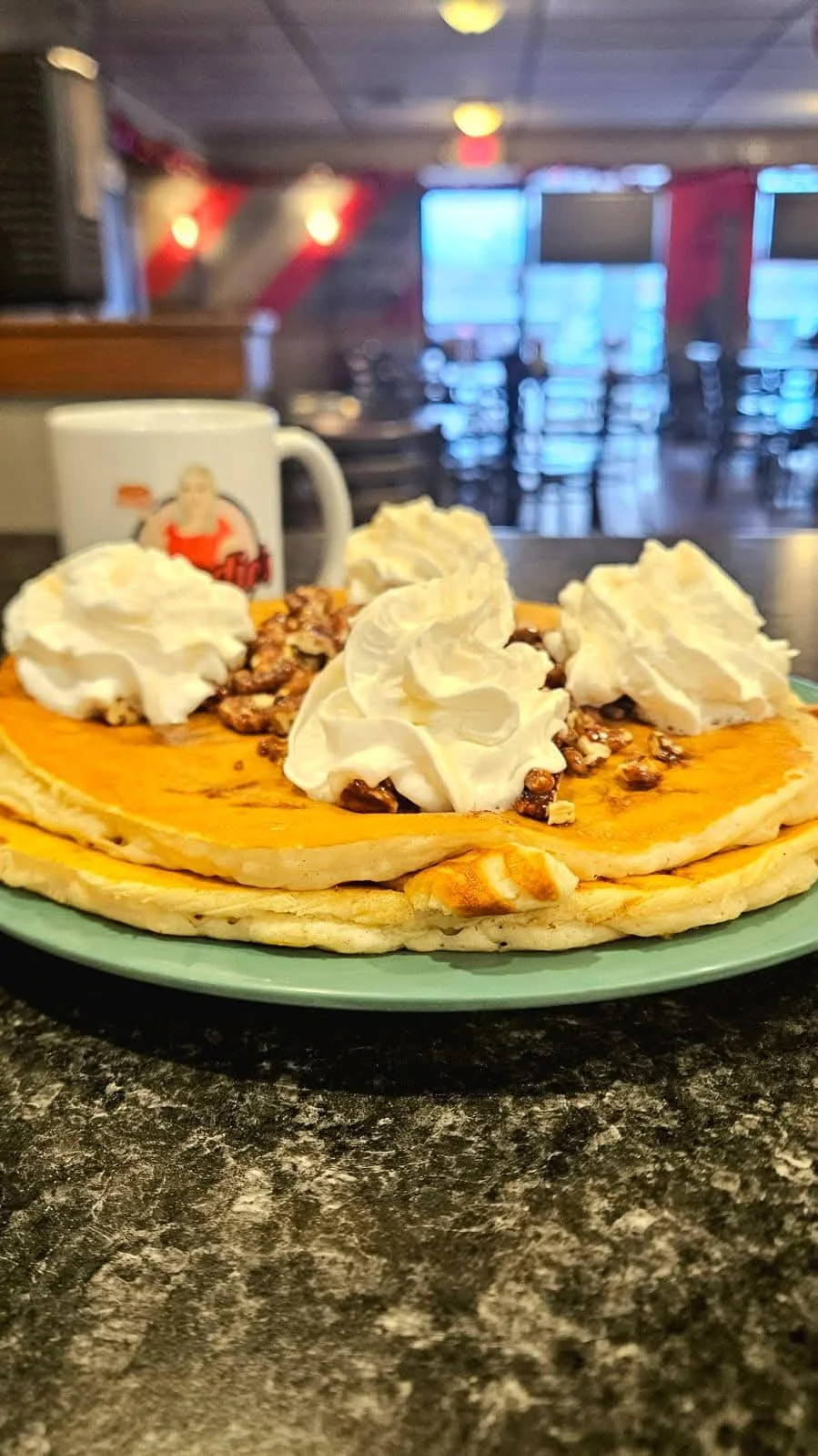 Fluffy pancakes topped with whipped cream and nuts