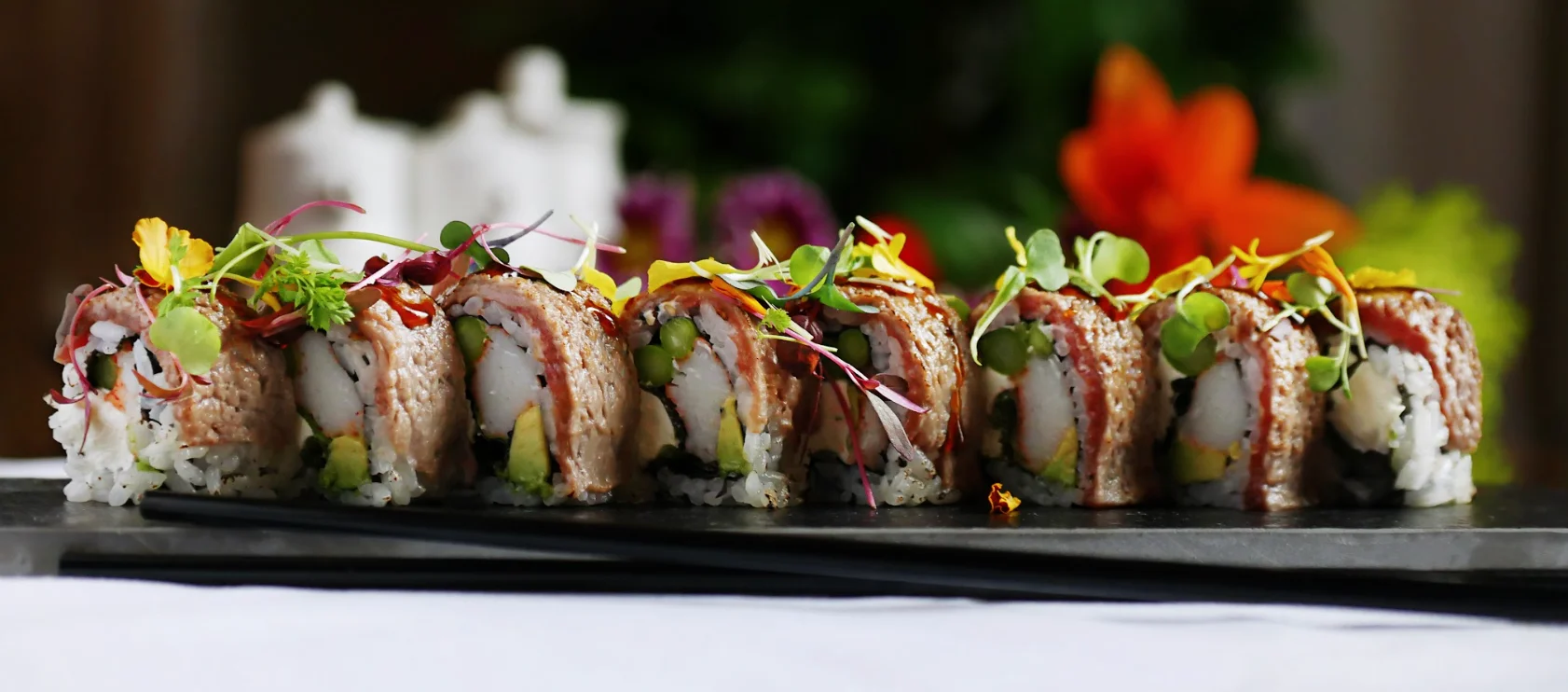 Japanese sushi rolls beautifully presented on a black slate platter
