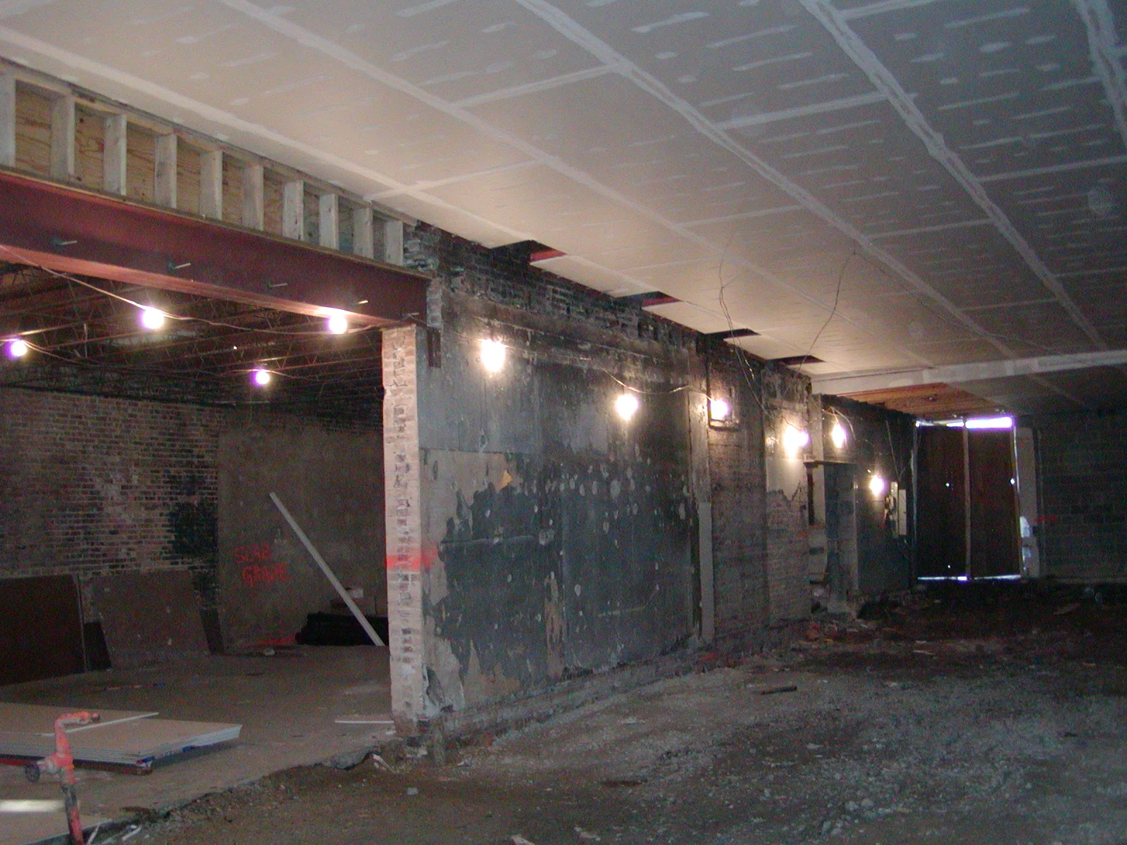 Empty restaurant interior with exposed brick and overhead lighting