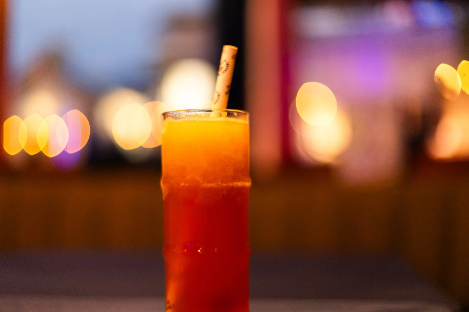 A colorful Wet Woody cocktail served in a tropical setting.