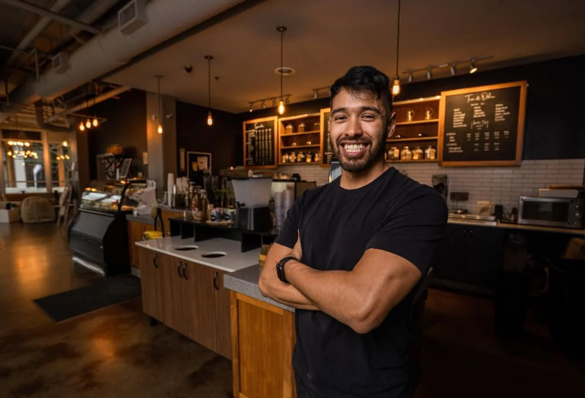 Smiling barista in a modern coffee shop interior