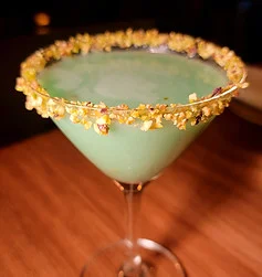 Vibrant green cocktail with floral rim in a stylish glass
