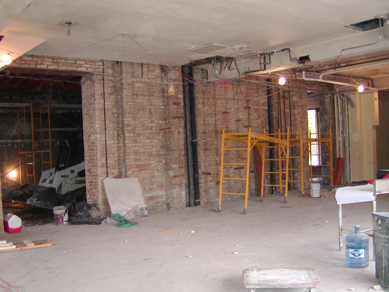 Interior of a restaurant under construction with workers and signage