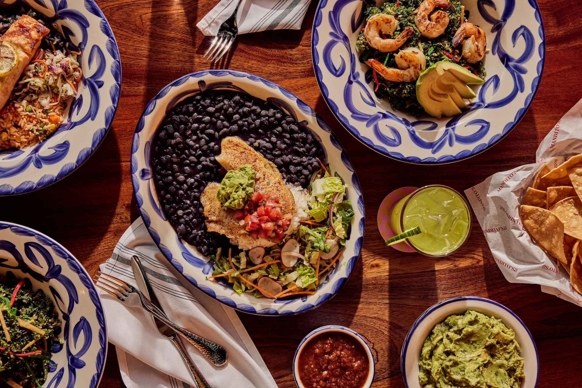 Colorful Mexican platter with grilled fish, black beans, and guacamole