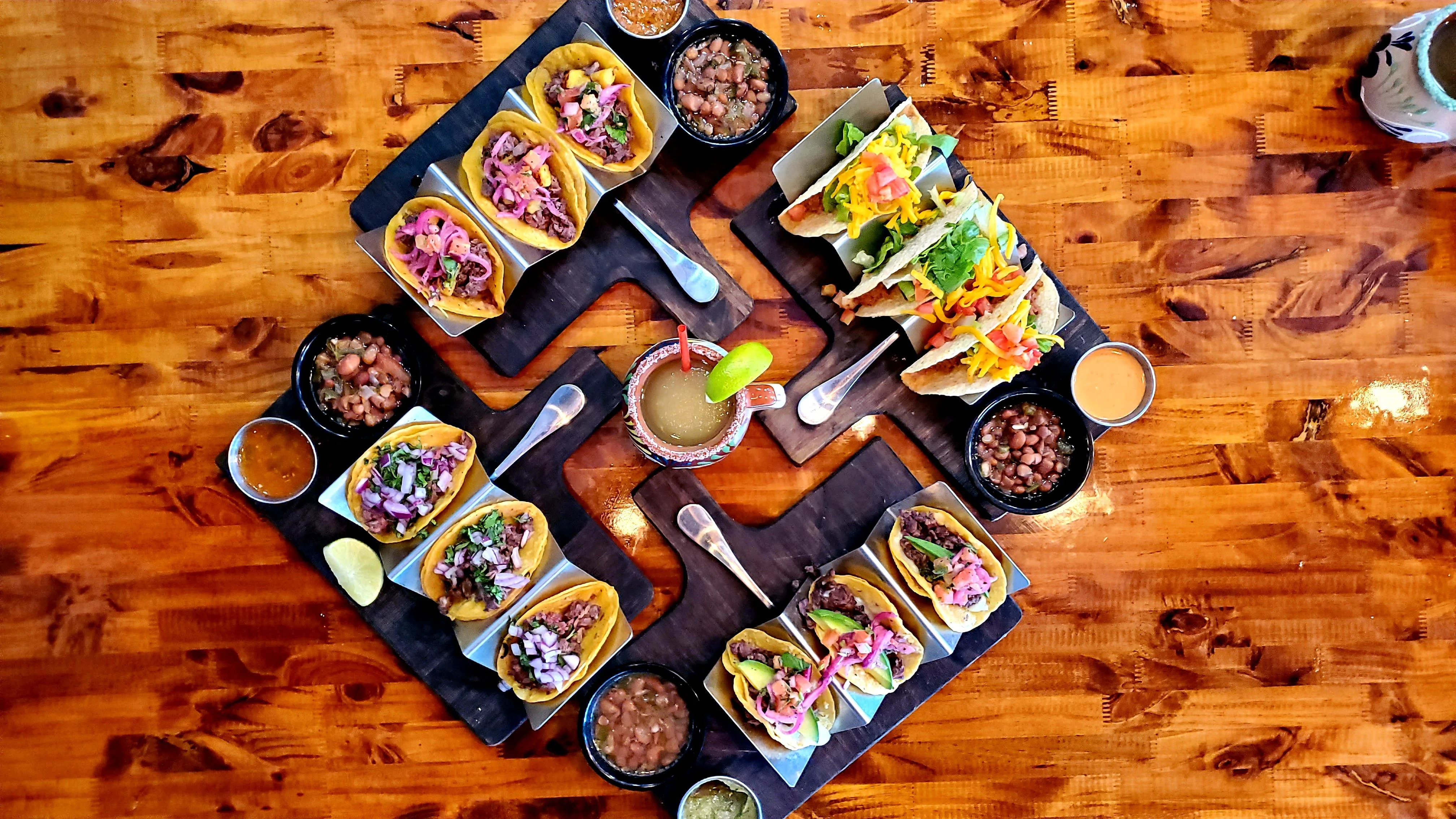 Assorted tacos served on wooden platters in a vibrant restaurant setting