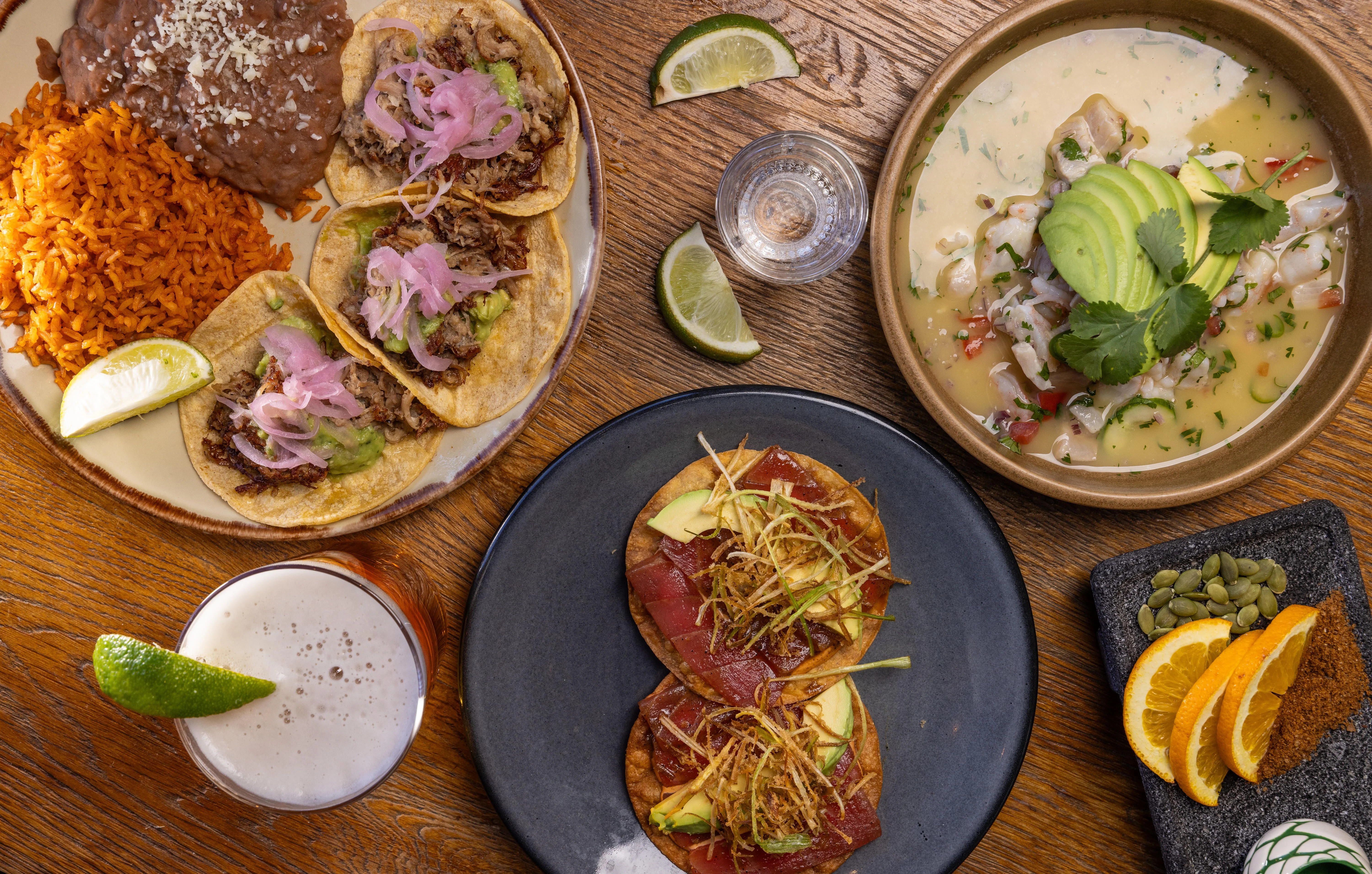 Colorful Mexican feast with tacos, enchiladas, and drinks