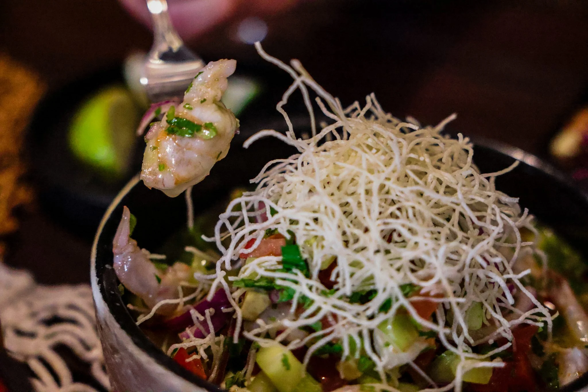 Ceviche with shrimp and crispy noodles in a vibrant bowl