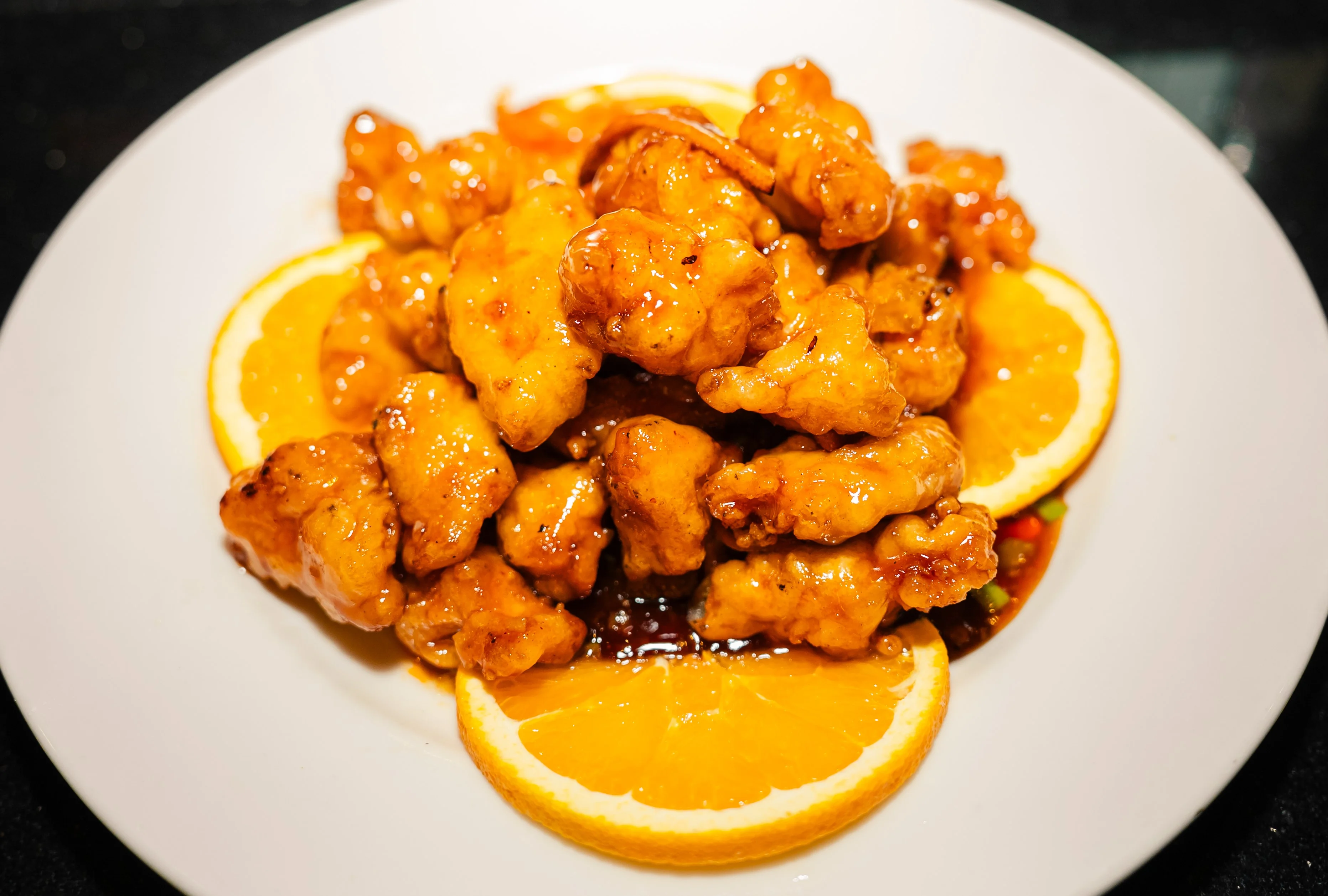Crispy orange chicken served with citrus slices