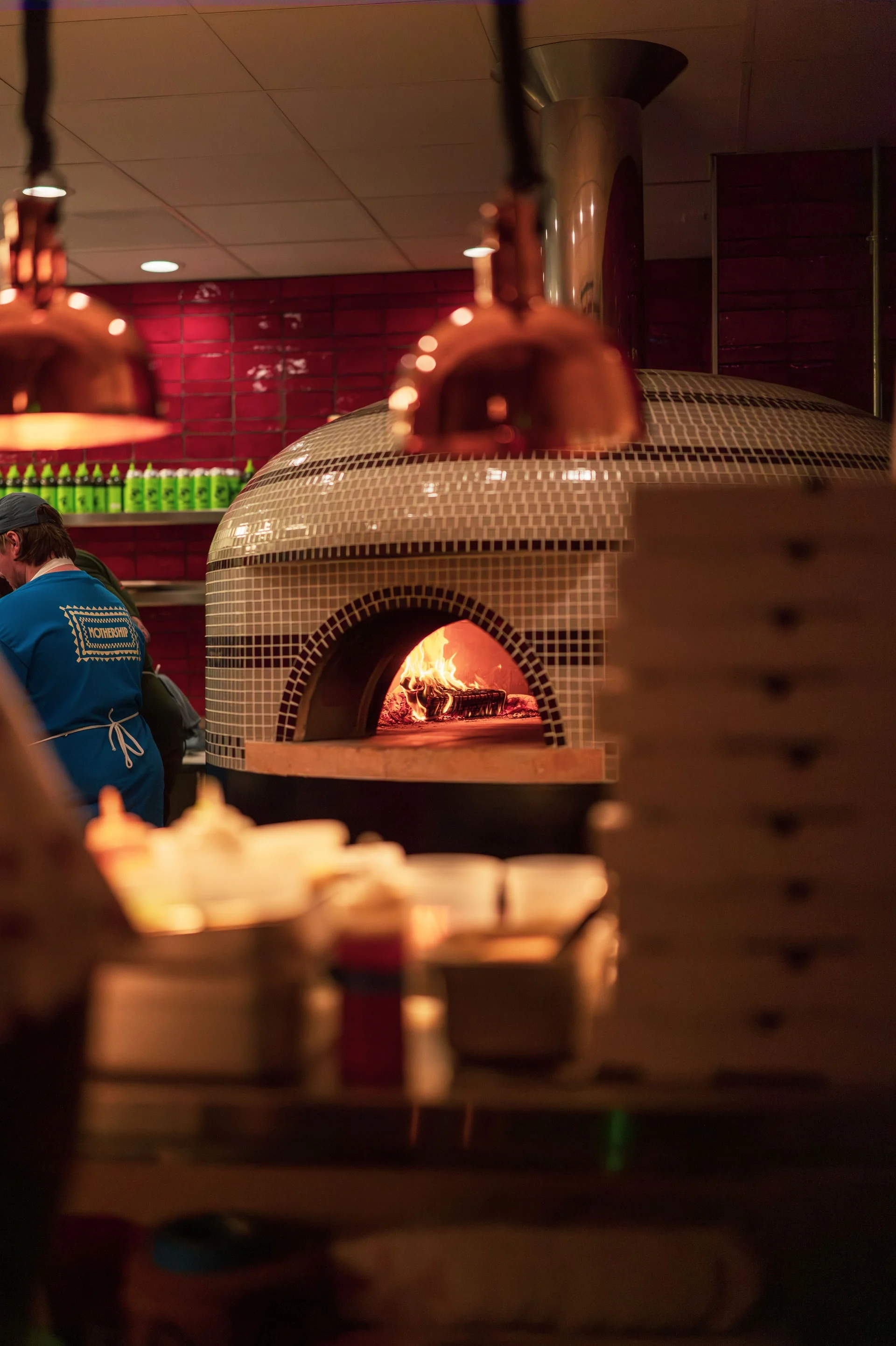 Wood-fired oven baking Margherita pizza in a vibrant restaurant
