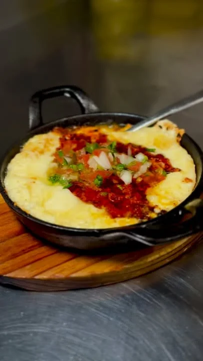 Mexican queso fundido served in a cast iron skillet