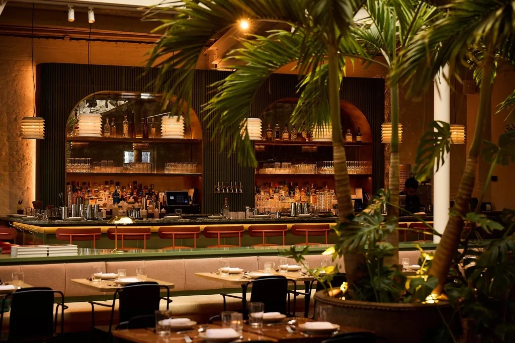 Stylish restaurant bar with tropical plants and warm lighting