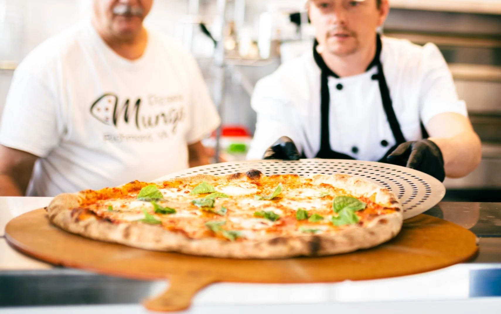 Pizza being pulled from a commercial oven