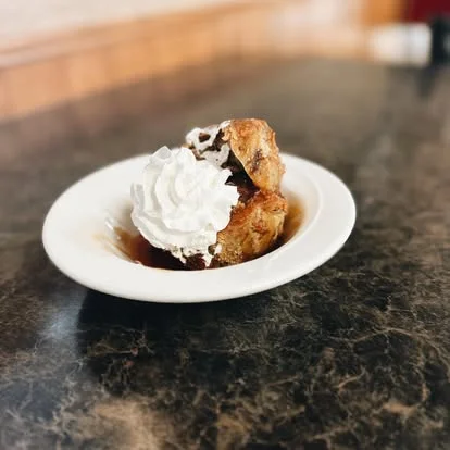 Delicious bread pudding topped with whipped cream