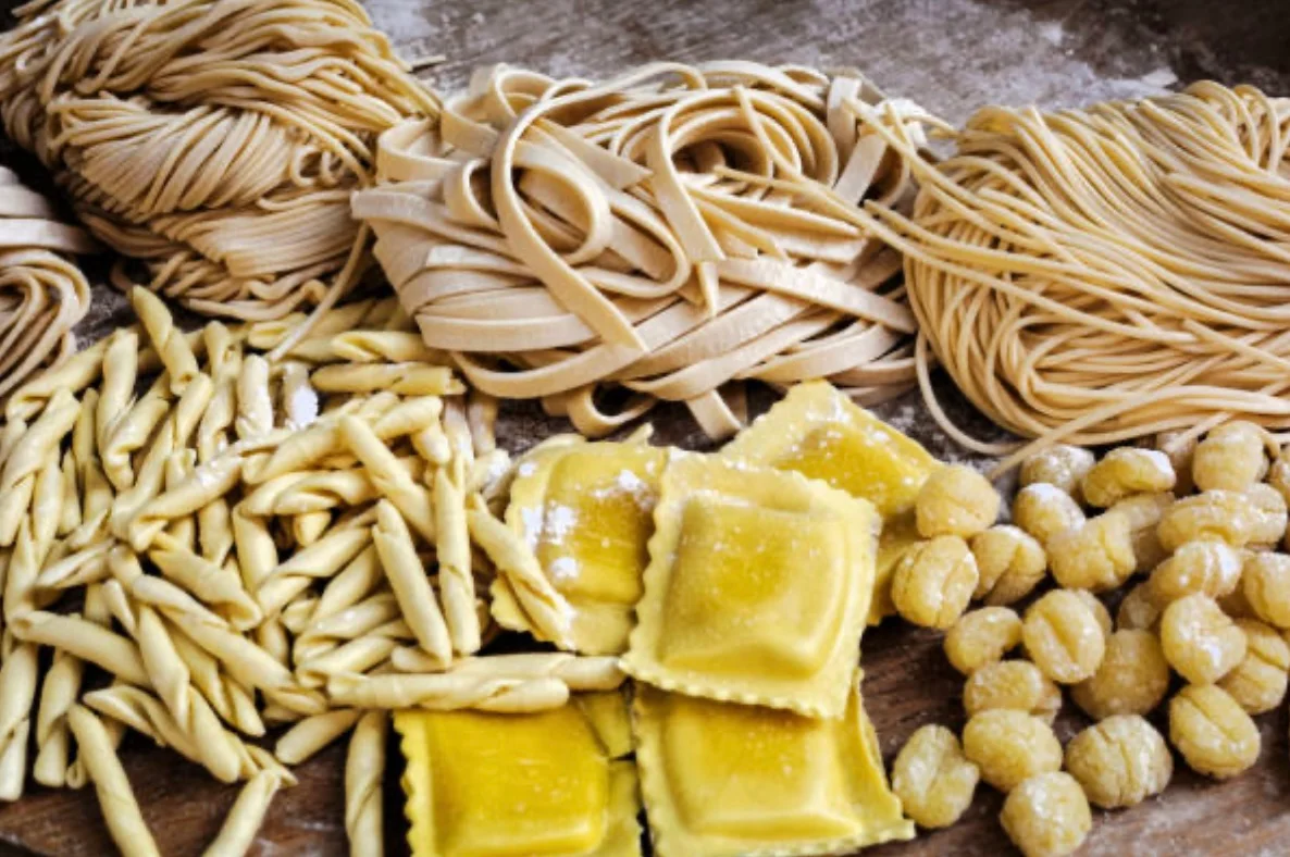 Assorted Italian pasta varieties on a wooden surface