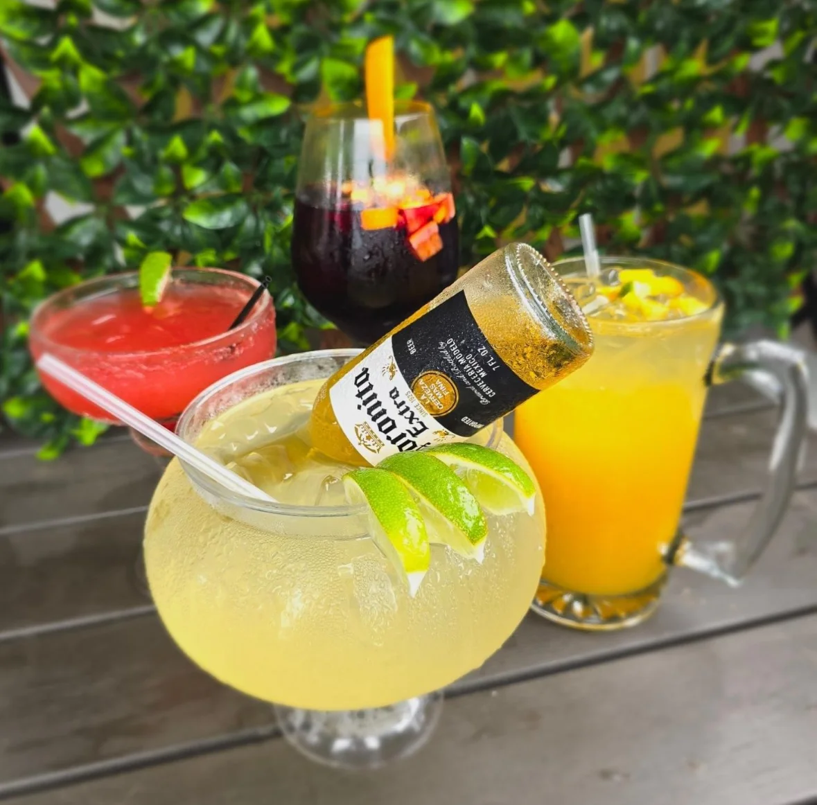 Colorful cocktails including margarita and sangria on a wooden table