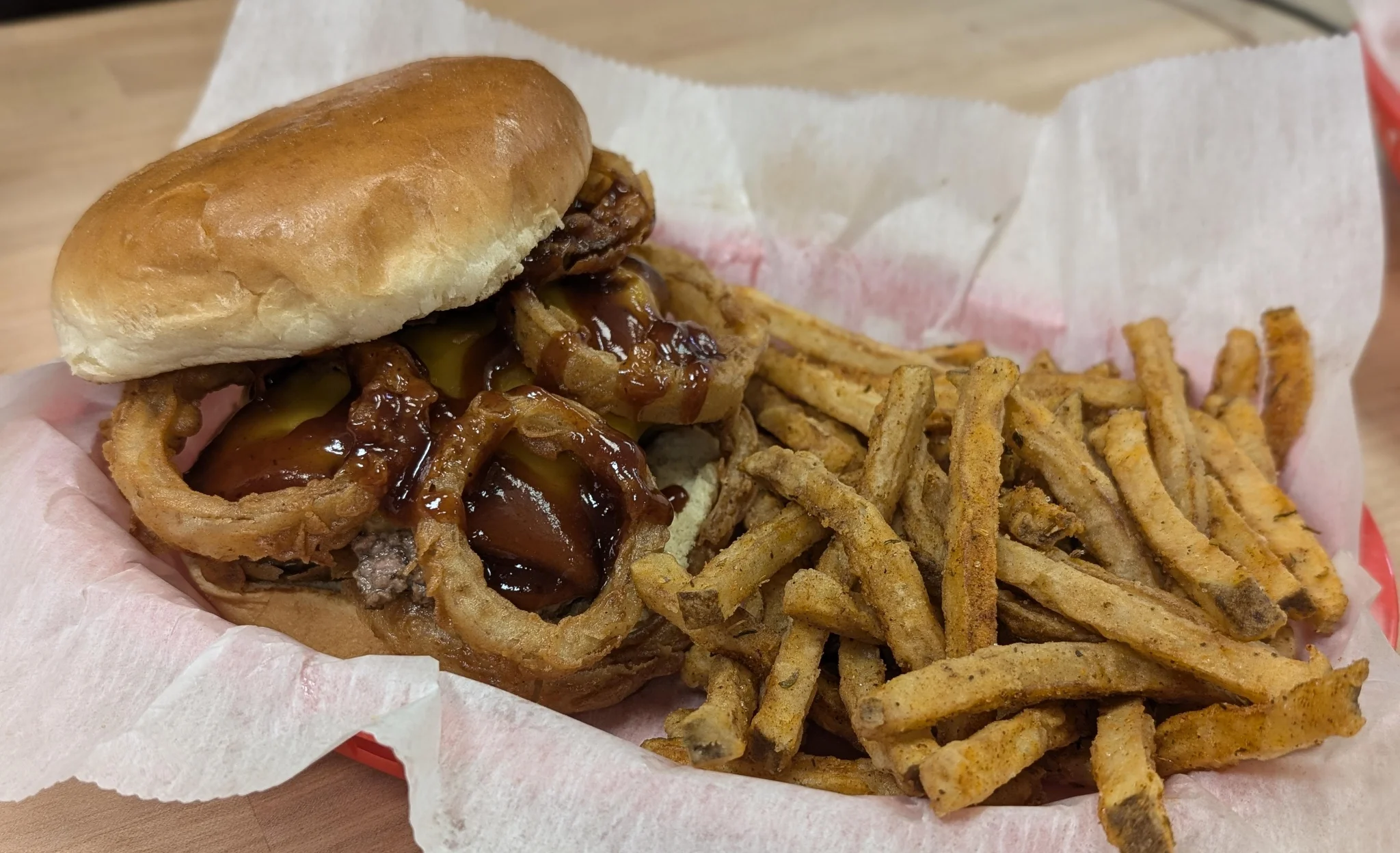 BBQ pulled pork sandwich with onion rings and fries
