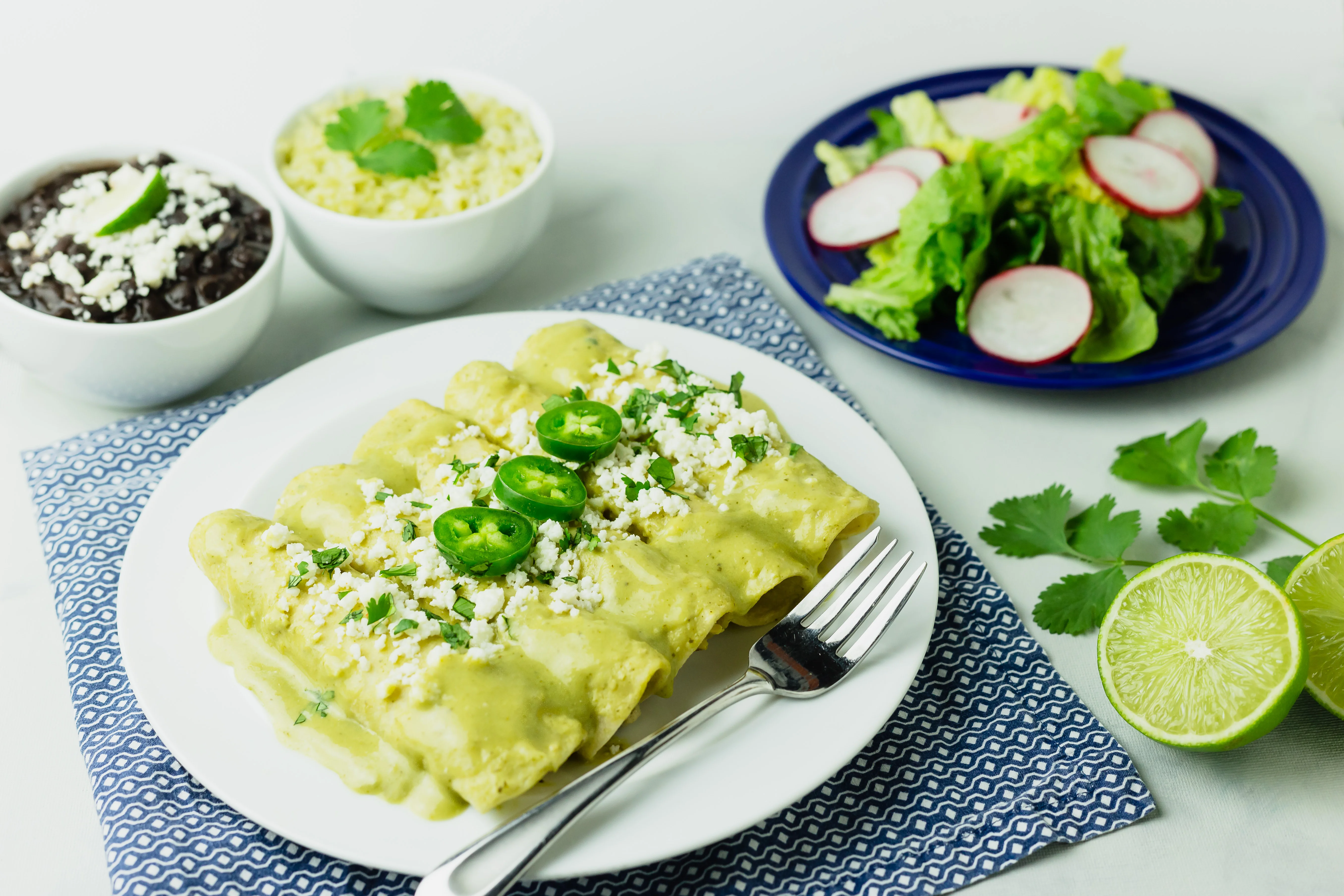 Plate of green enchiladas with toppings