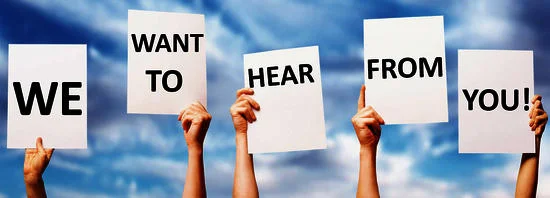People holding white signs reading We Want to Hear From You