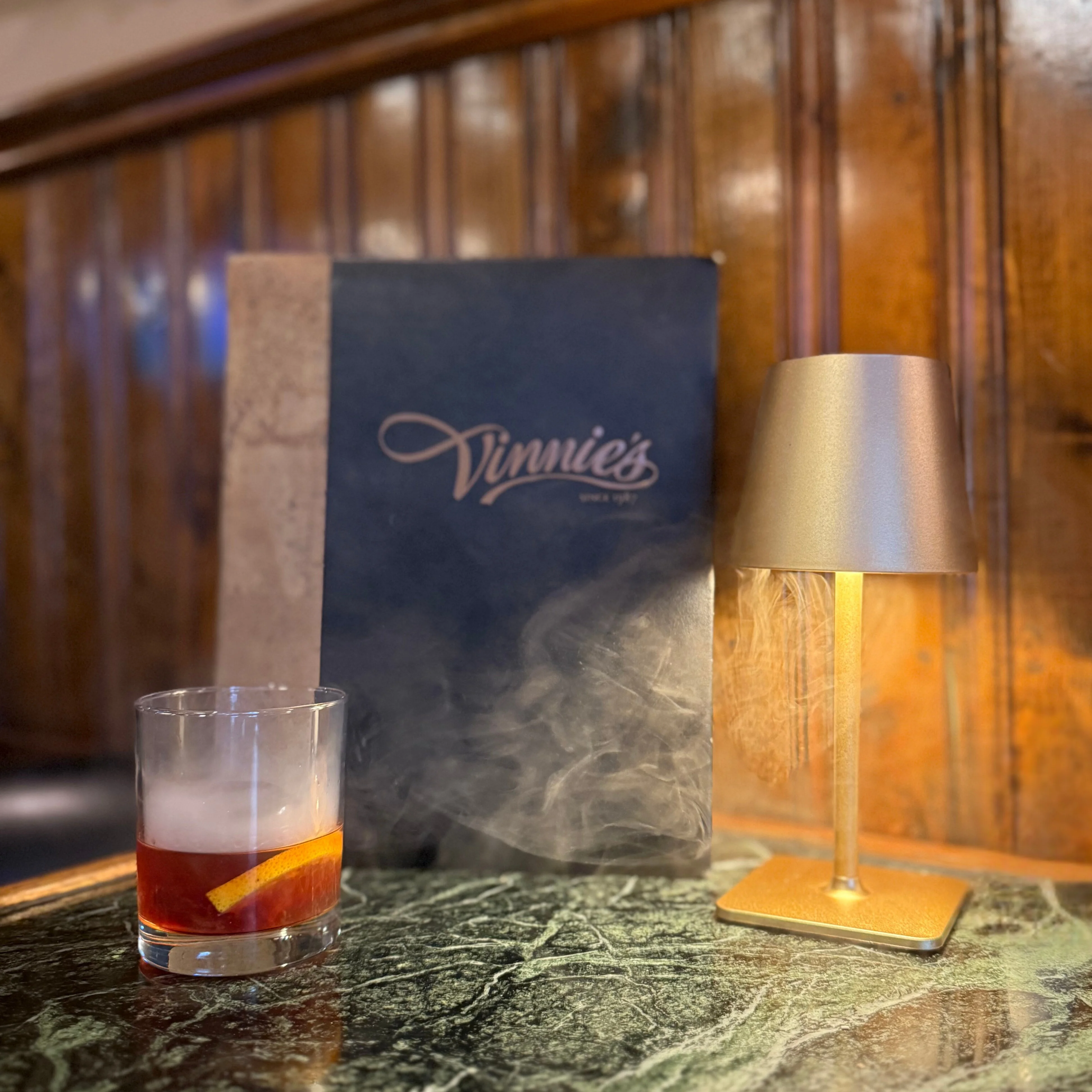Cocktail with smoke and lemon twist at Vinnie's restaurant
