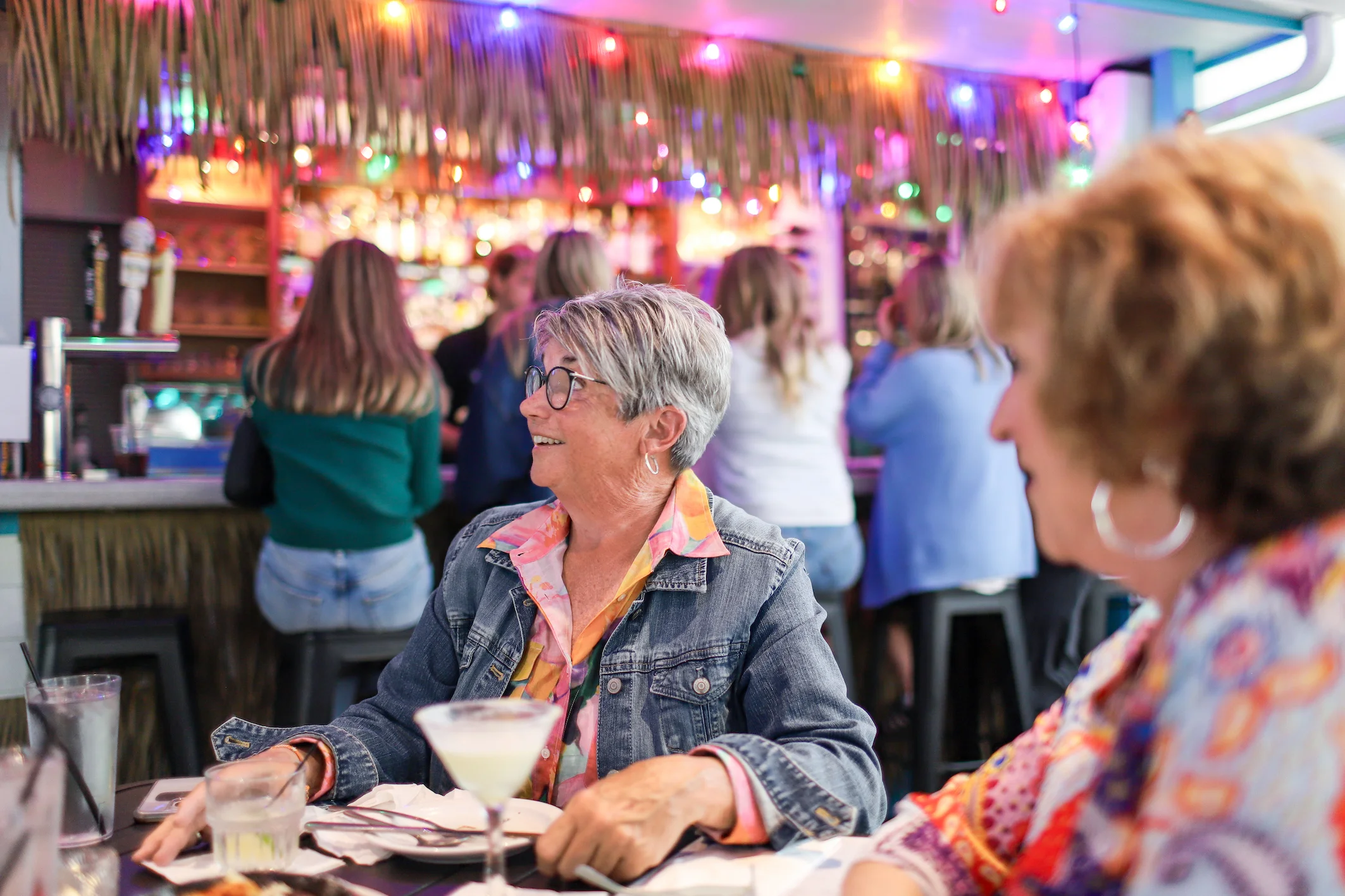 Lively restaurant scene with patrons enjoying drinks and conversation