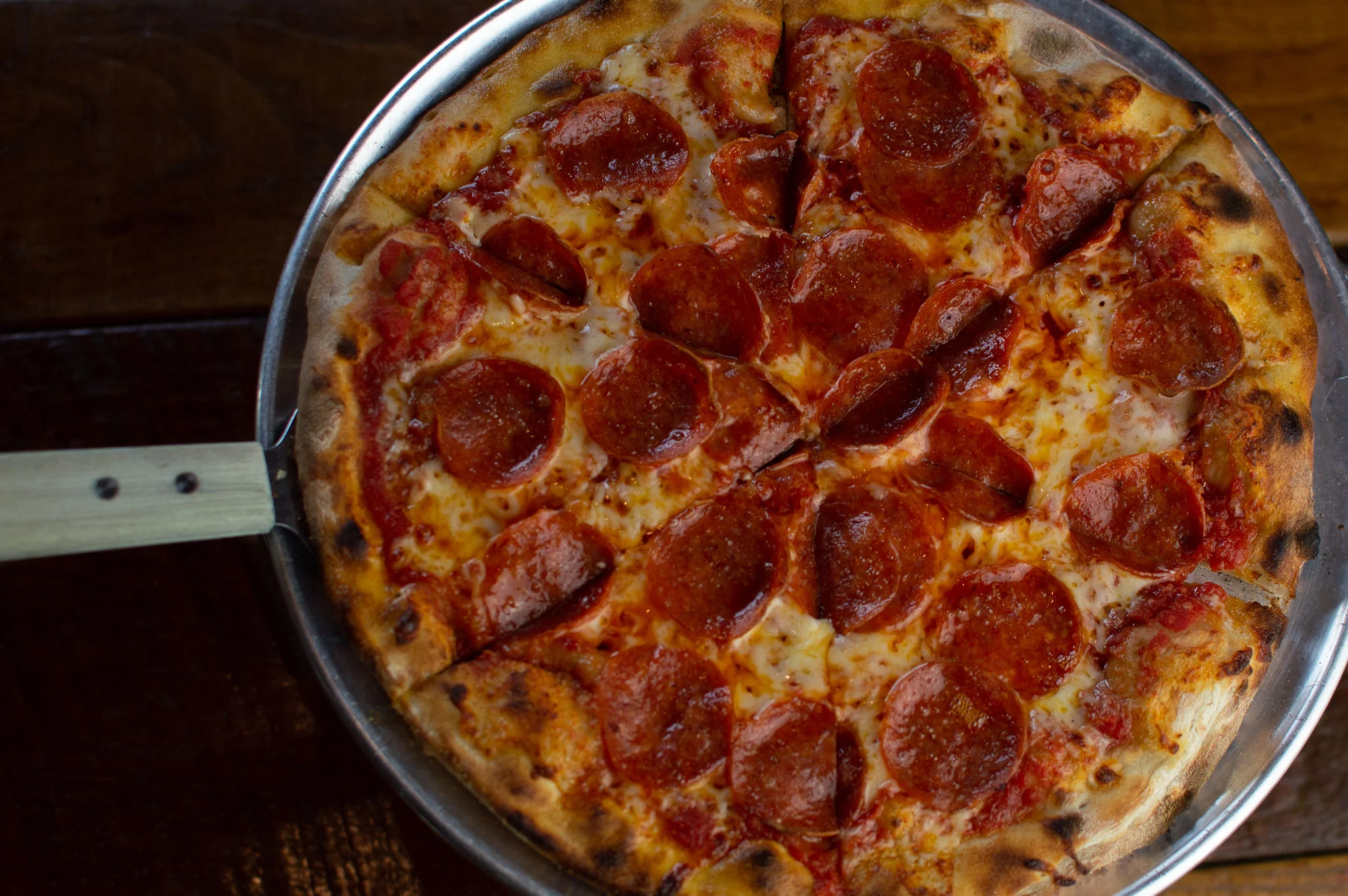 Pepperoni pizza served on a metal tray