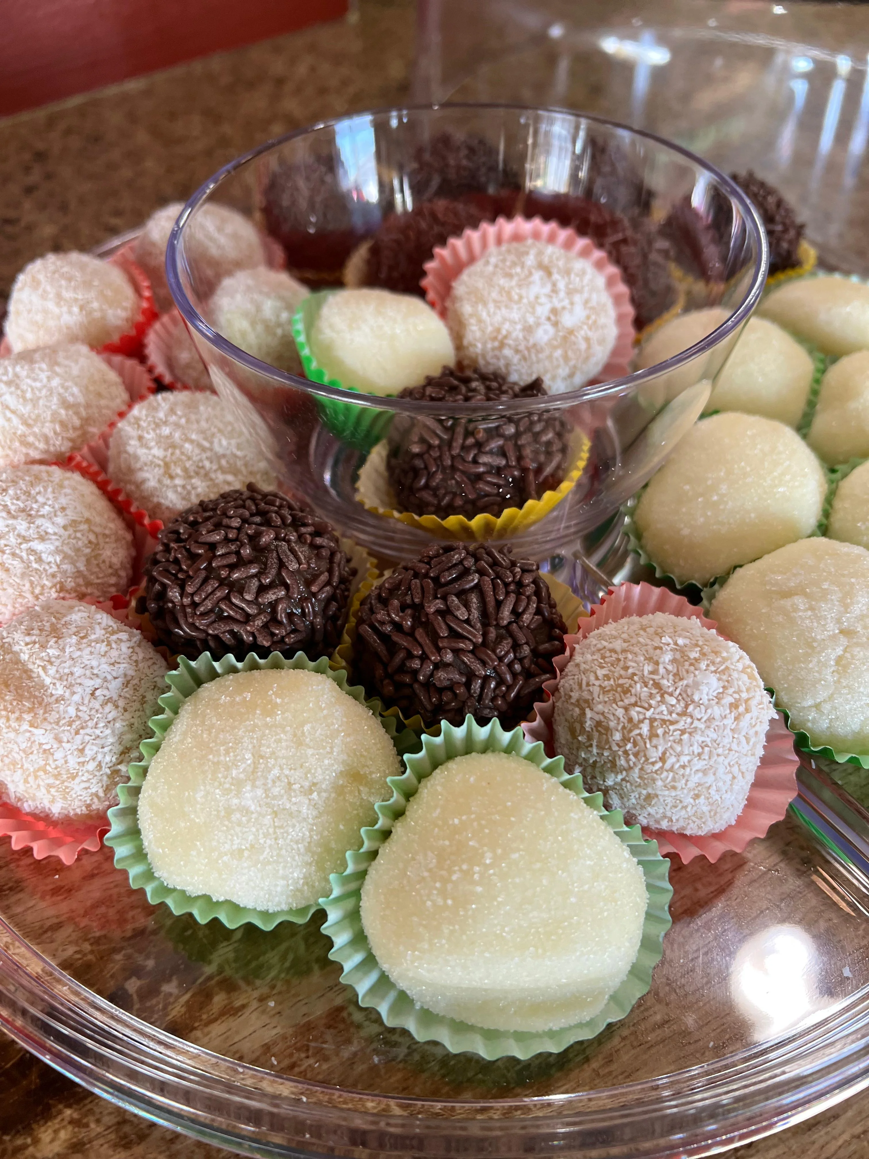A colorful assortment of bite-sized confections in pastel cupcake liners, featuring different textures and flavors.