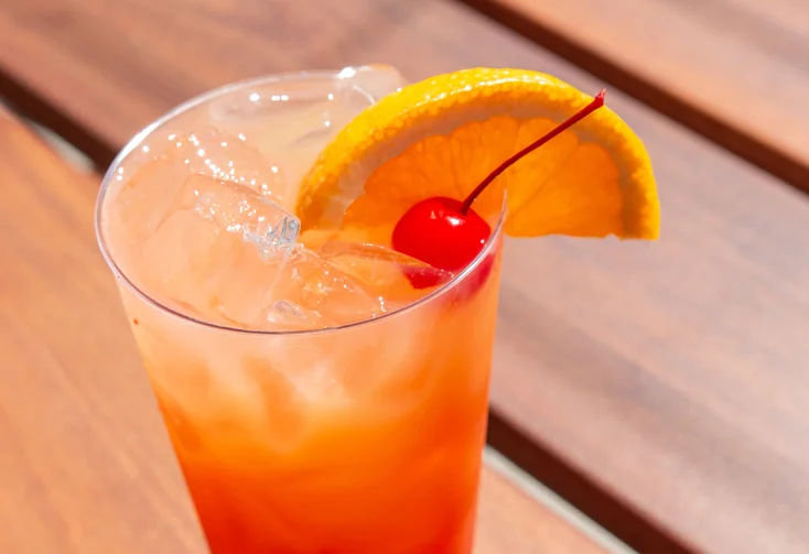 So cal sunrise drink with a cherry and orange garnish