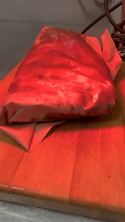 Wrapped brisket ready for smoking in a barbecue kitchen