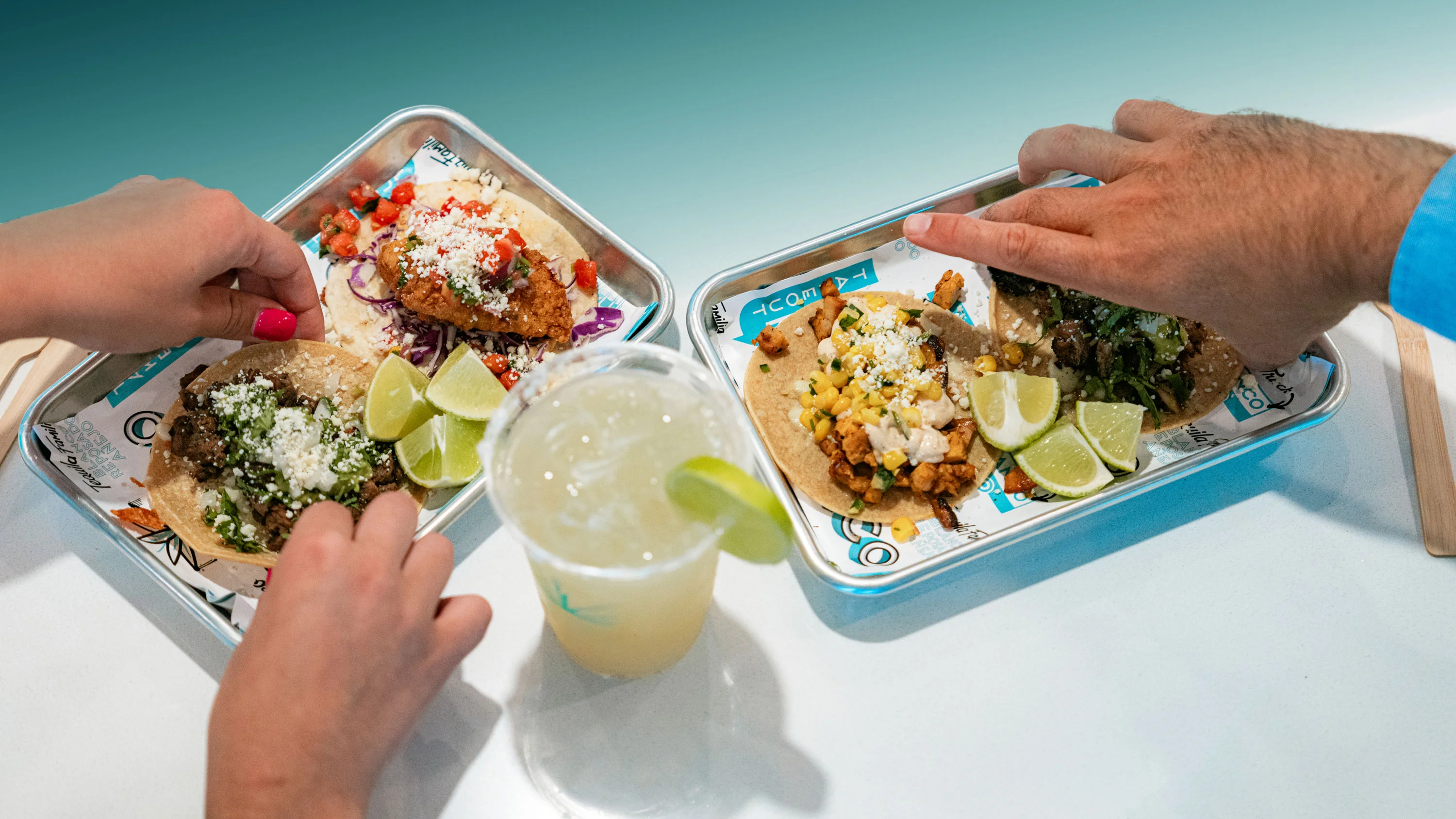 Taco Blanco trays with tacos and a margarita.