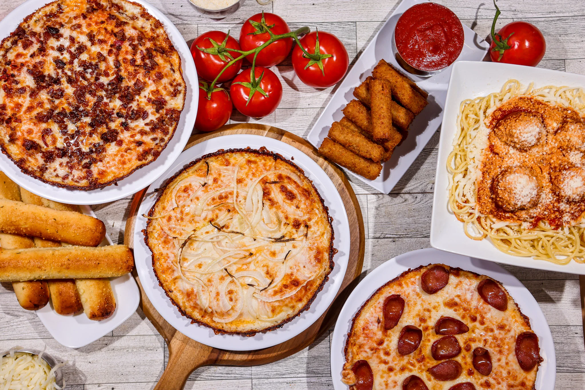 Assorted Italian pizzas and pasta with garlic bread
