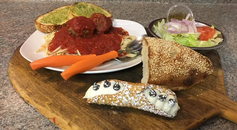 Classic Italian spaghetti and meatballs with garlic bread and cannoli