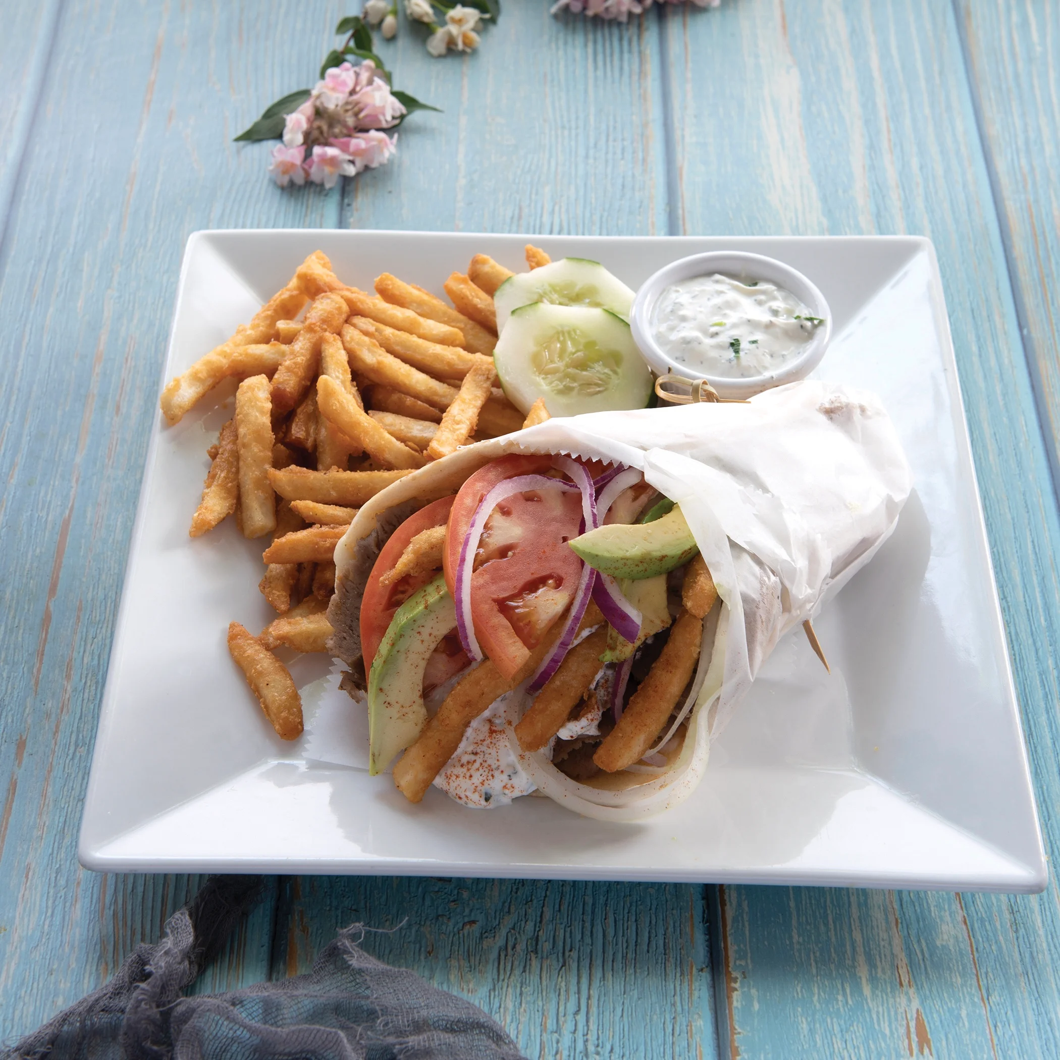 Mediterranean gyro wrap with fries and tzatziki sauce