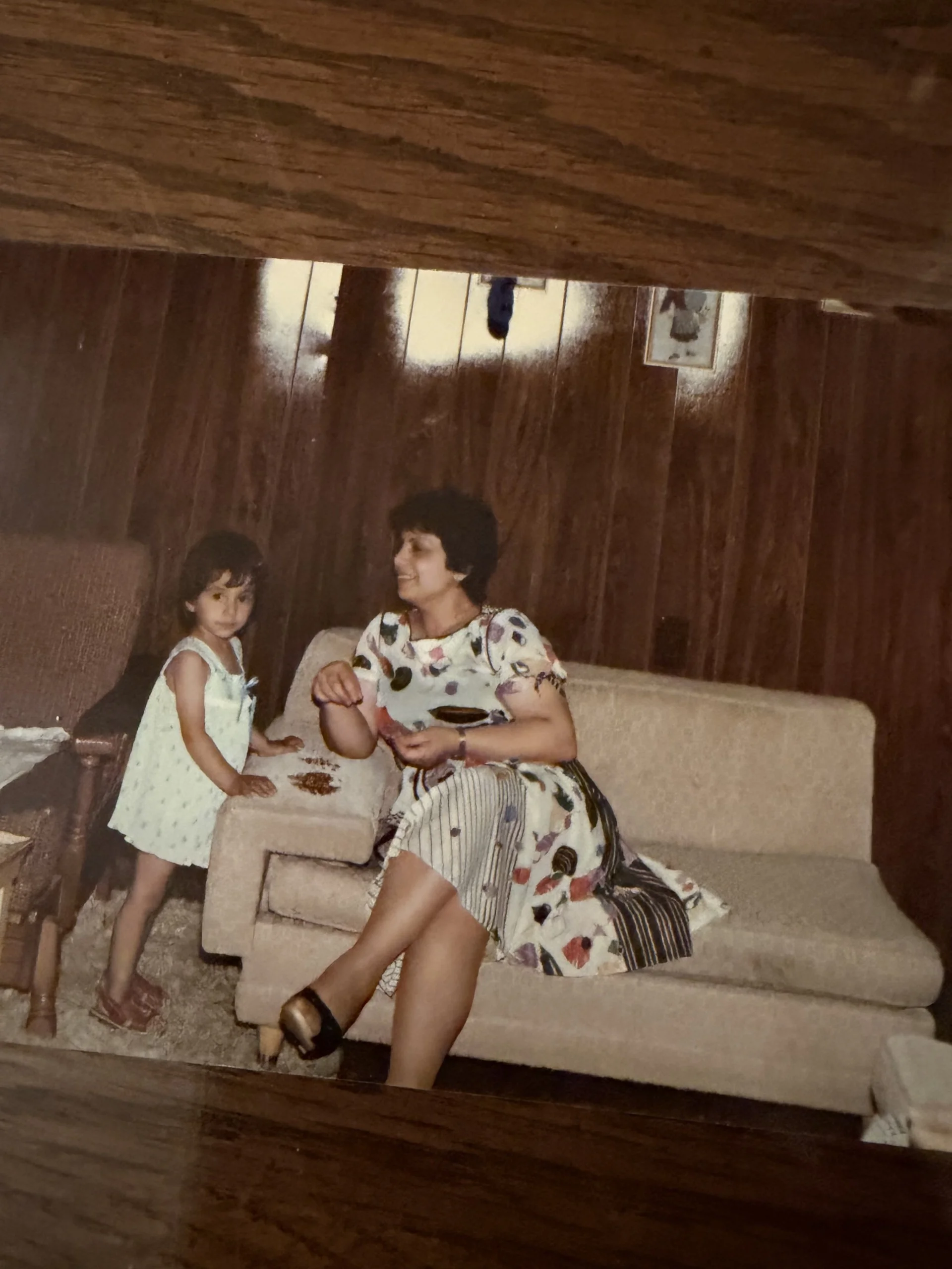 A woman and a child sitting on a couch in a cozy living room.