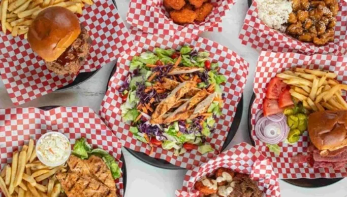 Assorted American comfort food platters with burgers and salads