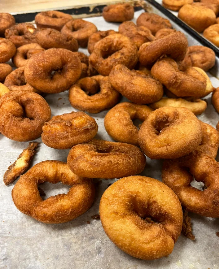 Freshly fried classic donuts on parchment paper
