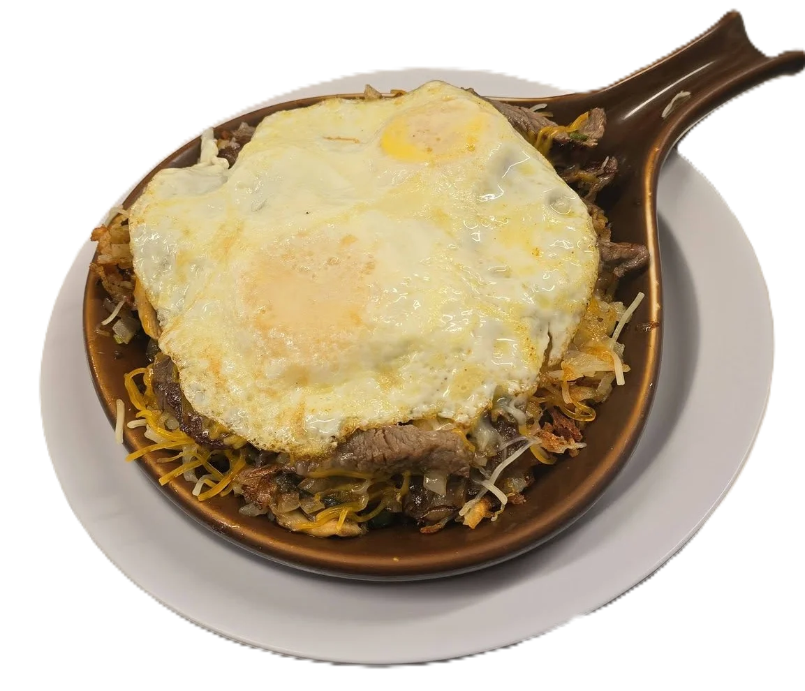 Sizzling carne asada with eggs on a hot plate