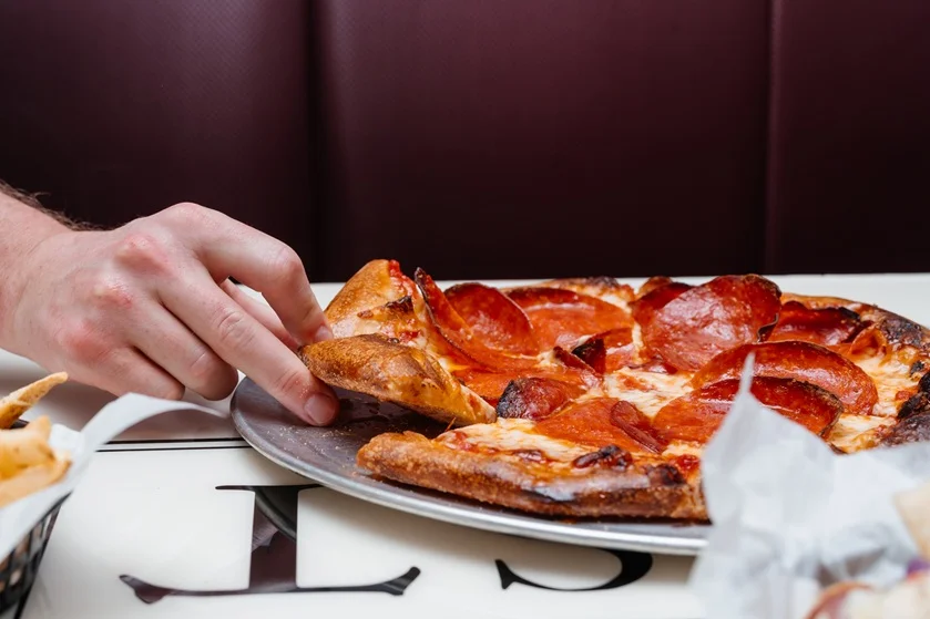 Pepperoni pizza served on a metal platter