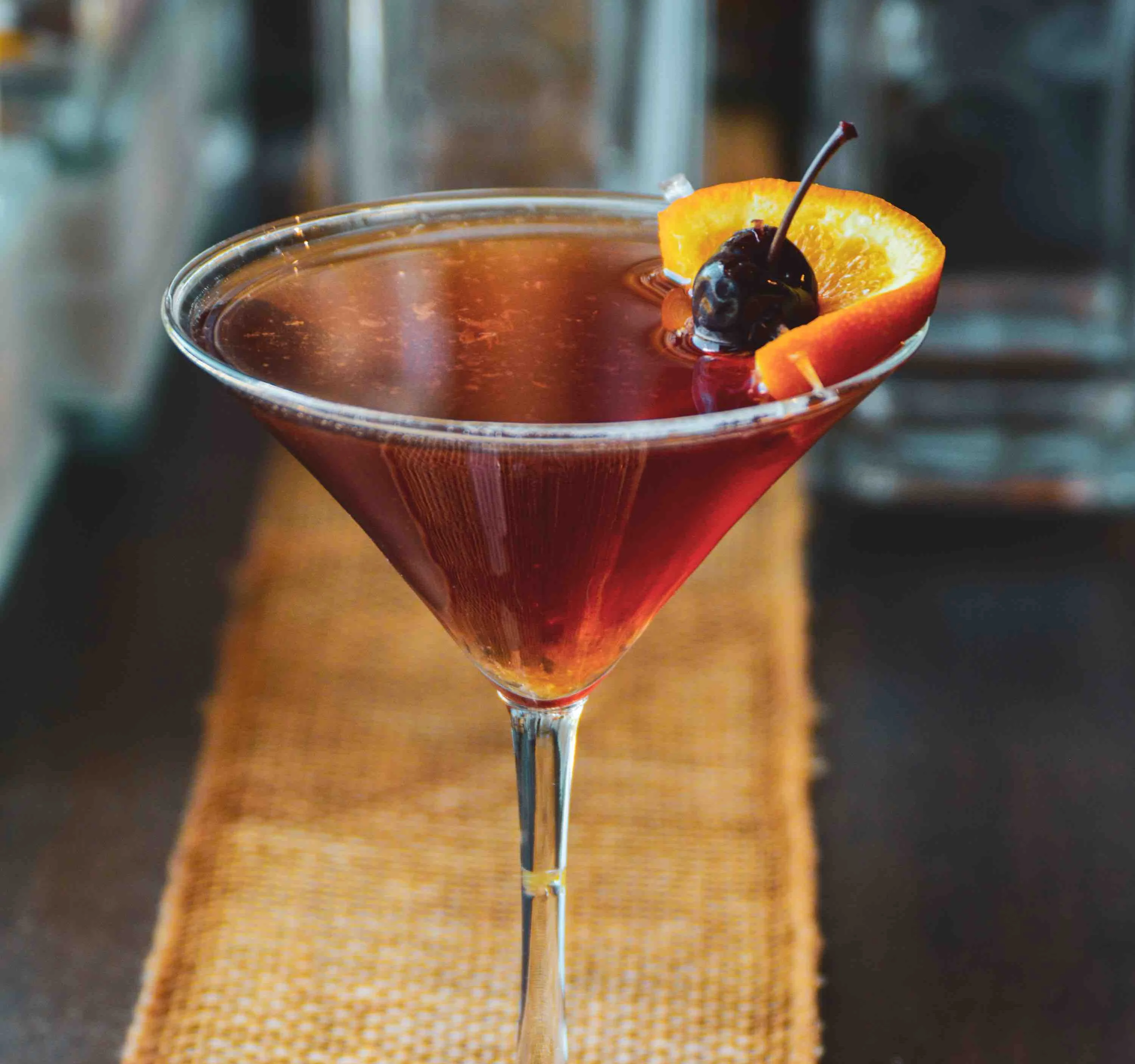 Old Gin Up Martini with a cherry and an orange slice on a wooden table
