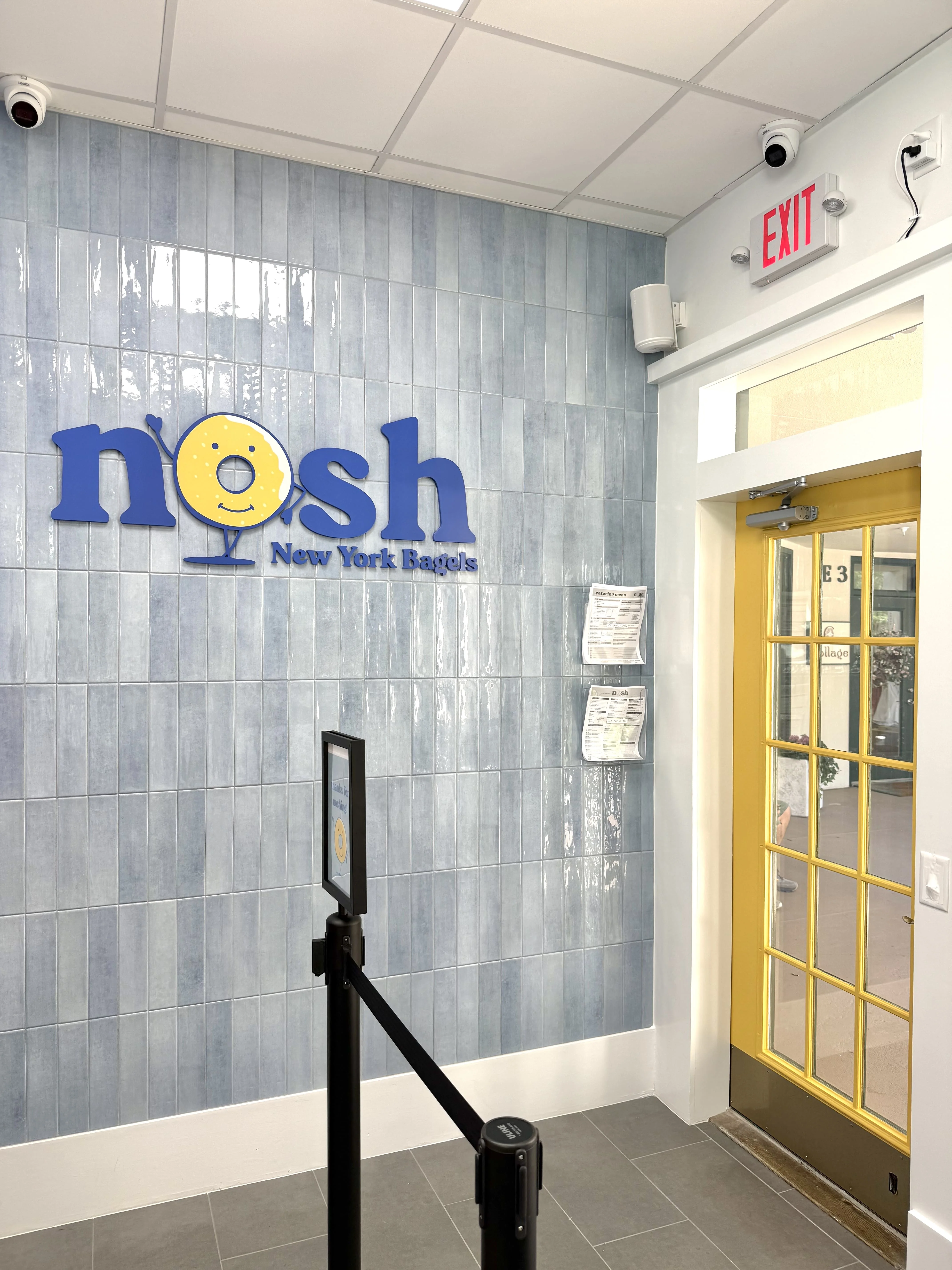 nosh NY bagels owners celebrating the Hilton Head Island grand opening with a cake.