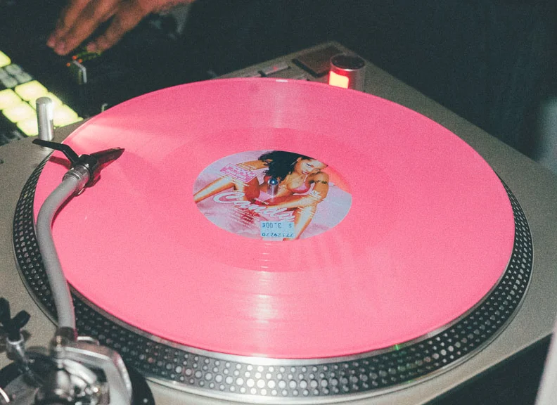 Pink vinyl record on a turntable at a DJ setup