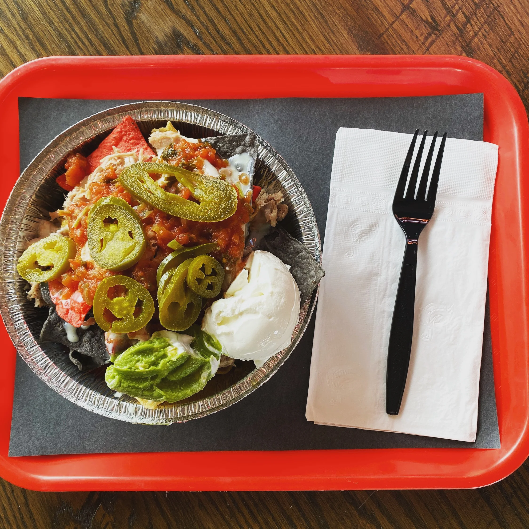 A delicious burger with toppings served on a wooden table.