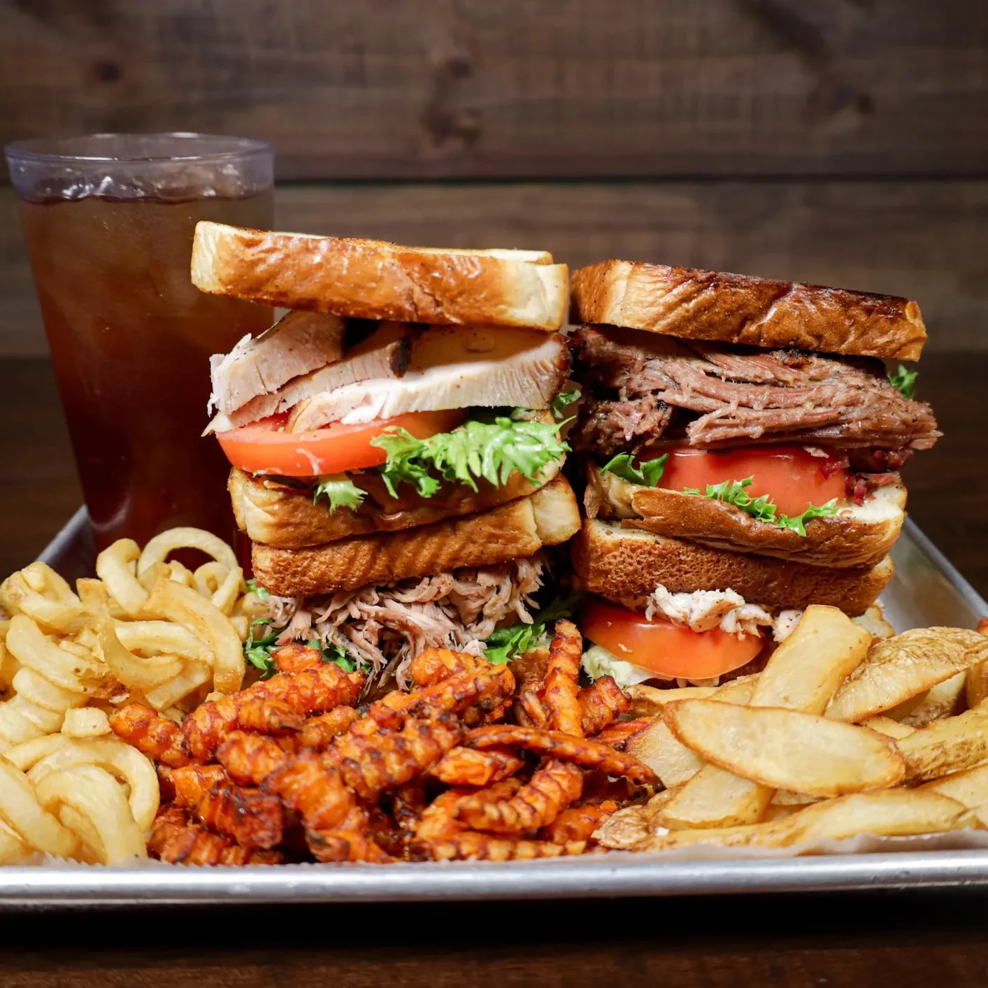 Hearty BBQ sandwich platter with pulled meats and sides