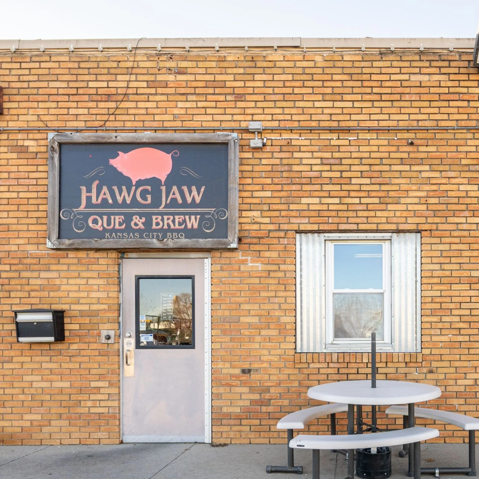 Kansas City barbecue restaurant exterior with brick wall and vintage pig sign