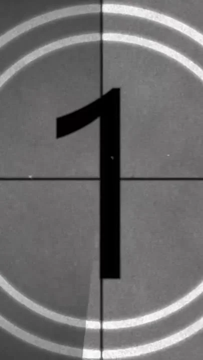 A film countdown showing the number one on a retro background with circular lines.
