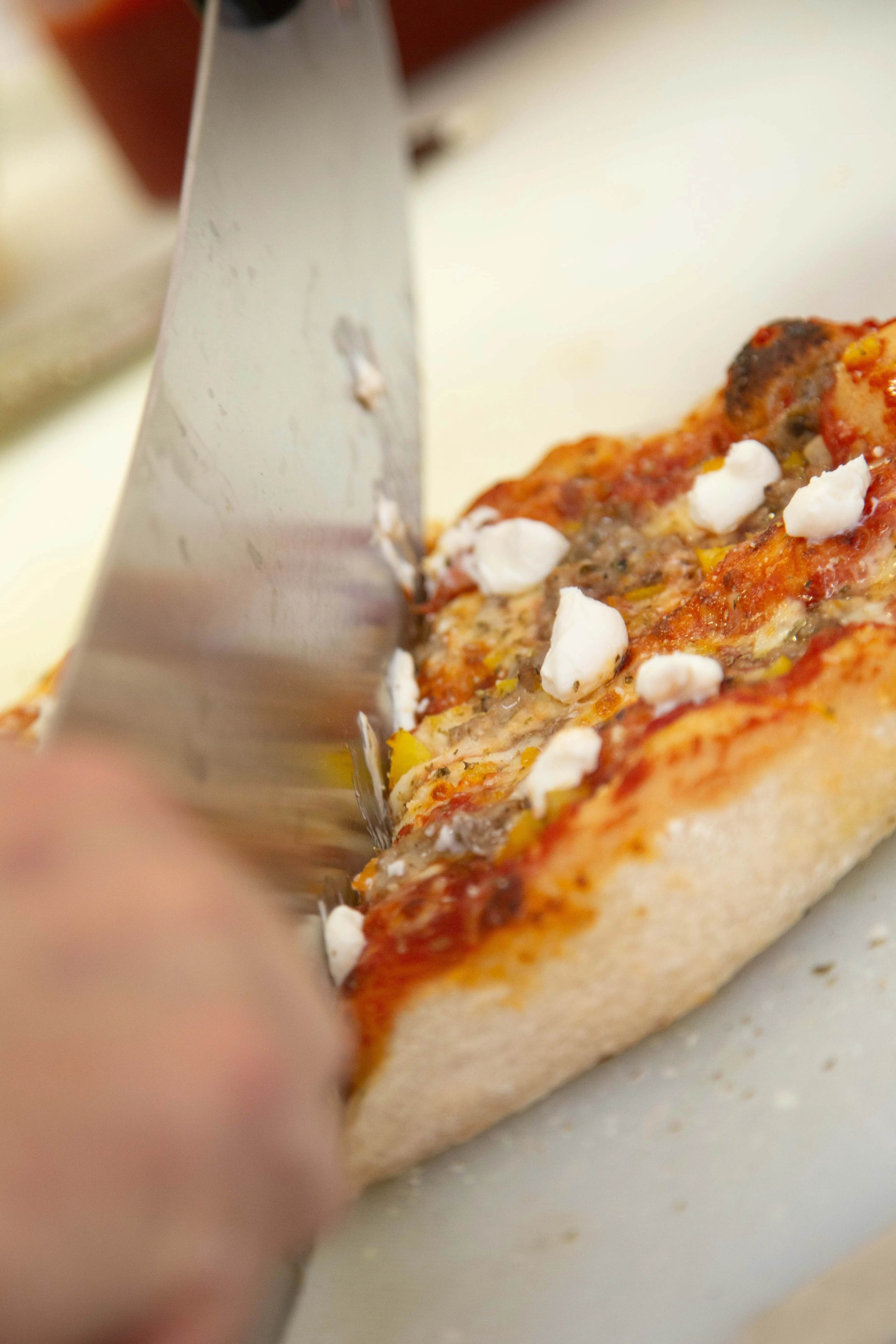 Slicing a delicious Margherita pizza with fresh mozzarella