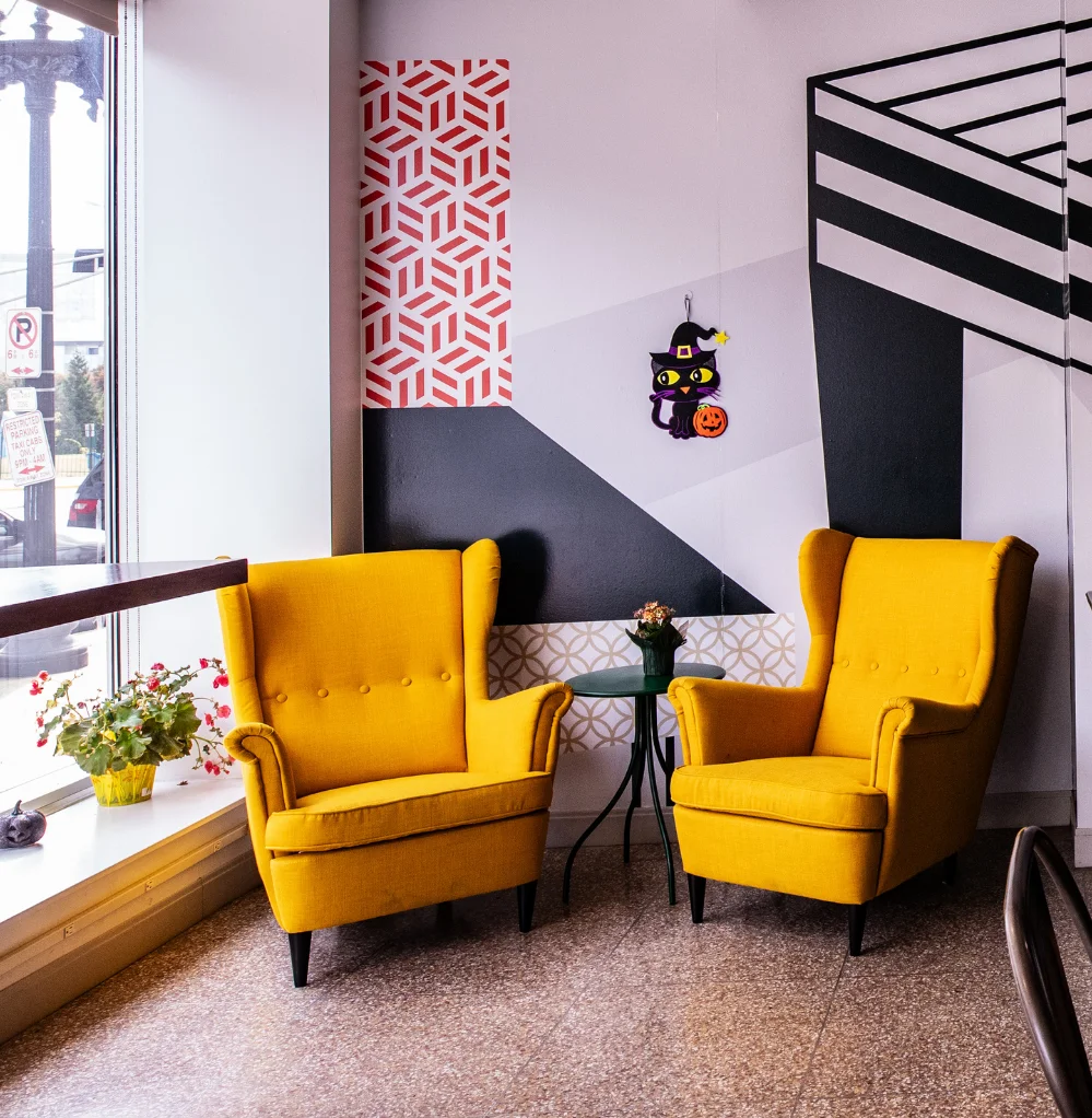 Cozy café corner with yellow armchairs and modern wall art