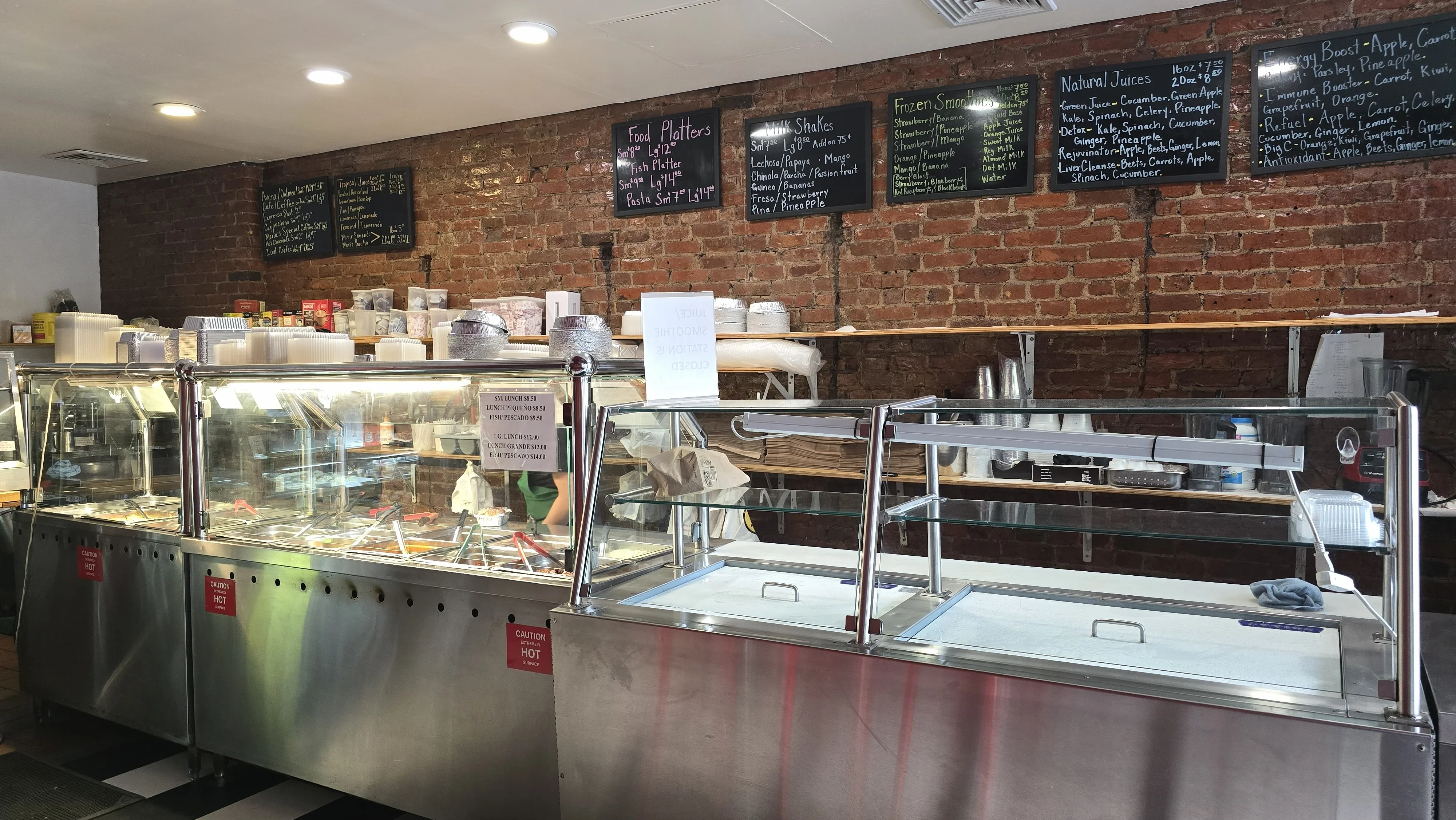 Cozy restaurant interior with a display of food options and chalkboard menus