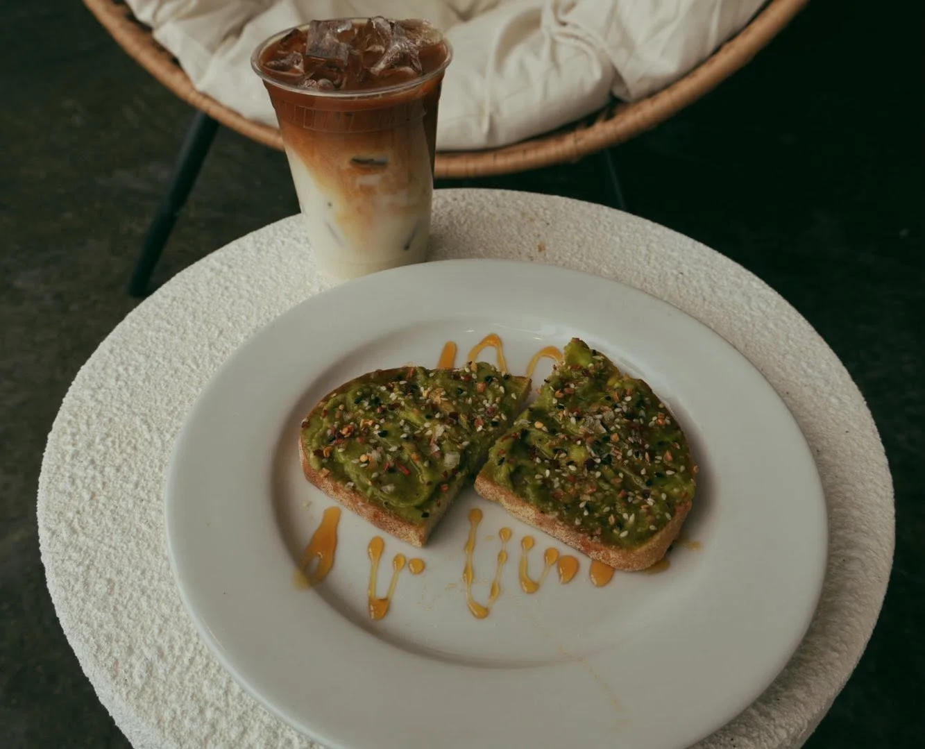 Avocado toast with sesame seeds and iced coffee on a table