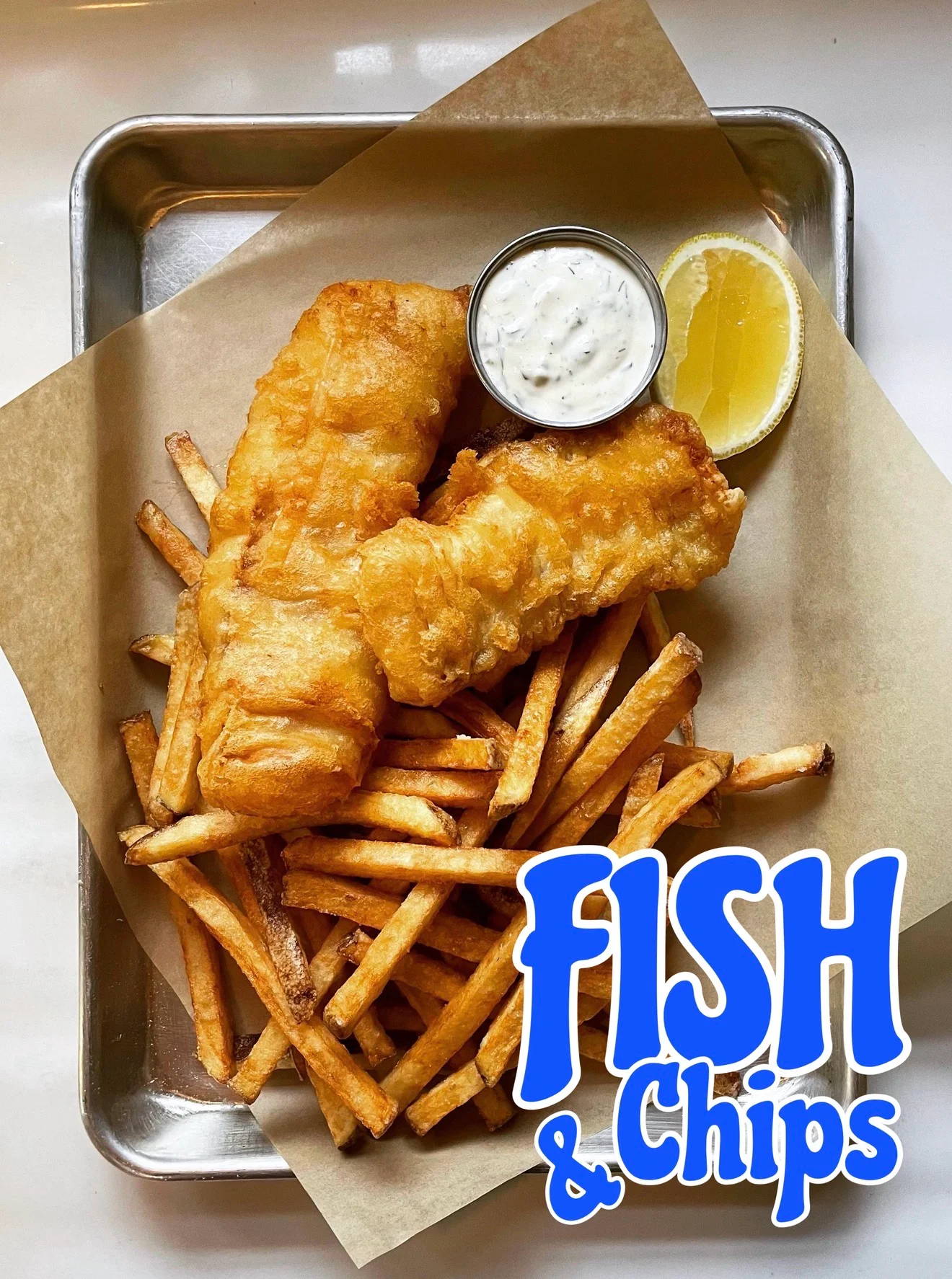 Classic British fish and chips served with tartar sauce and lemon